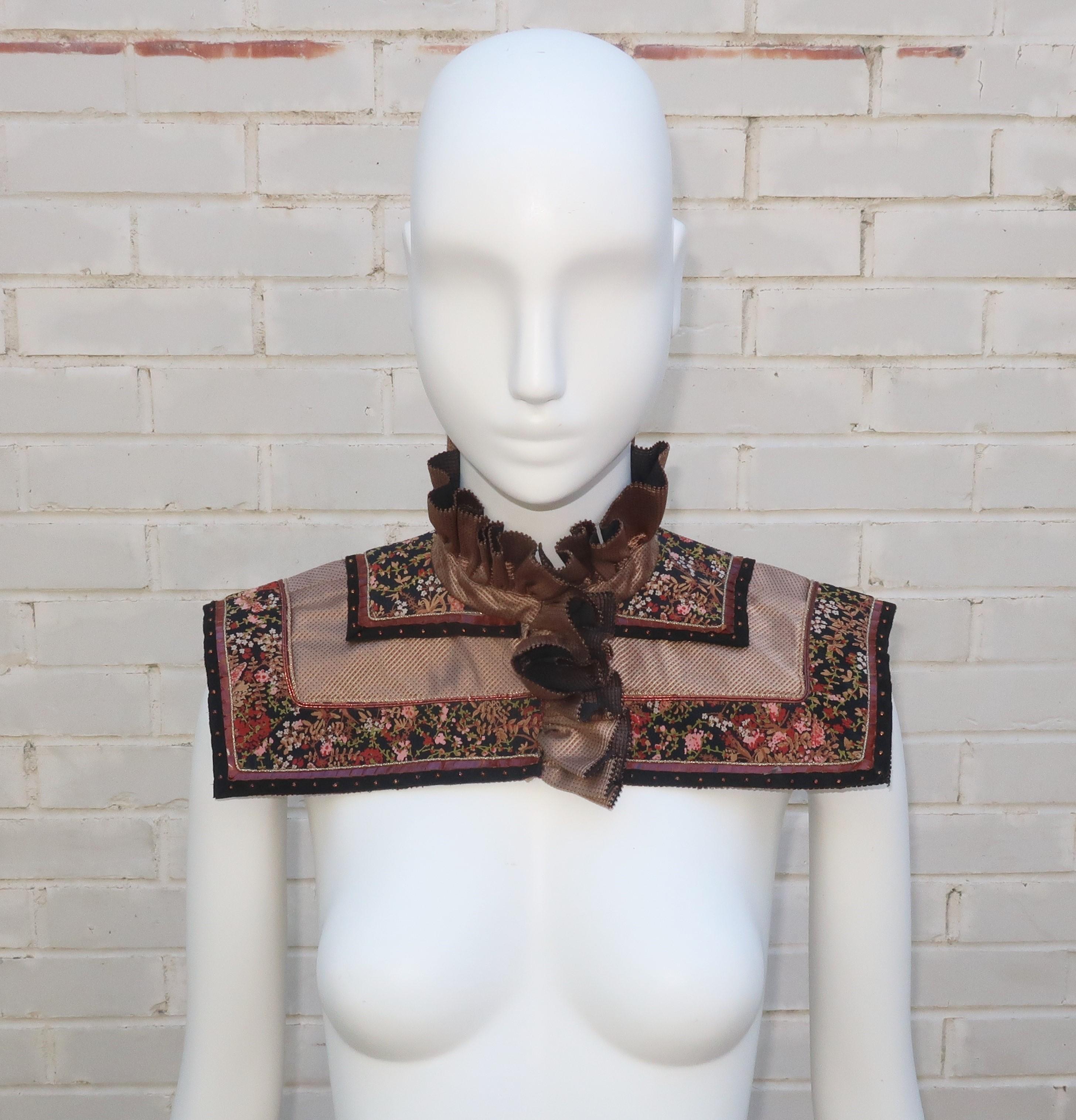 Vintage ruffled collar in shades of black and tan with layers of a brocade silk fabric, a dark floral print crepe trimmed in studded black trim, gold braid and snakeskin edging.  The collar has hidden hooks and can be worn over a simple neckline to