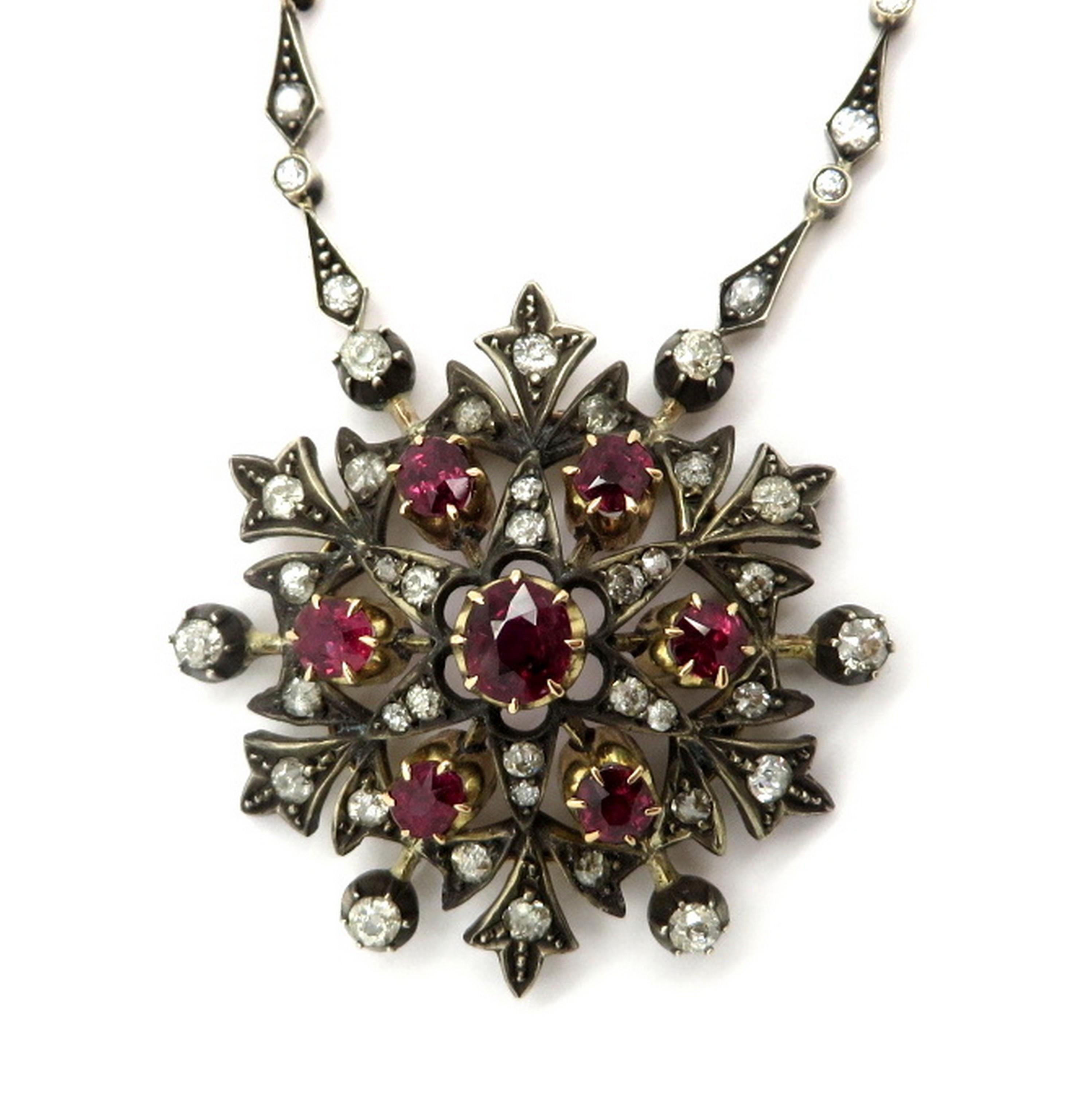 Victorian style silver and 18K yellow gold floral ruby and diamond necklace. Showcasing seven round and oval shaped fine quality natural rubies weighing a combined total of approximately 4.50 carats. Interspersed with numerous Old Mine cut bead,