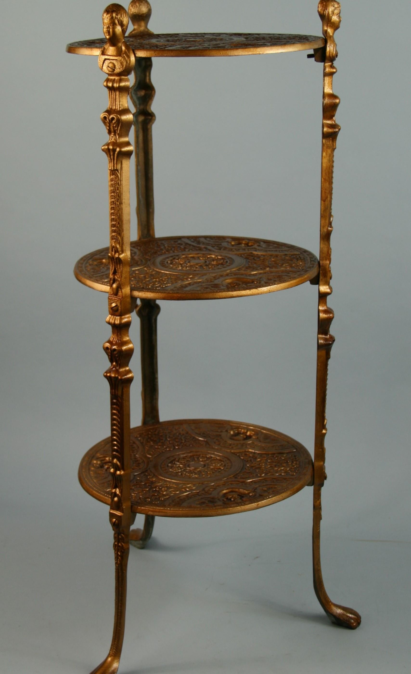 3-584 Victorian 3 tier cast metal shelf/plant stand with figural and repousse detailing.