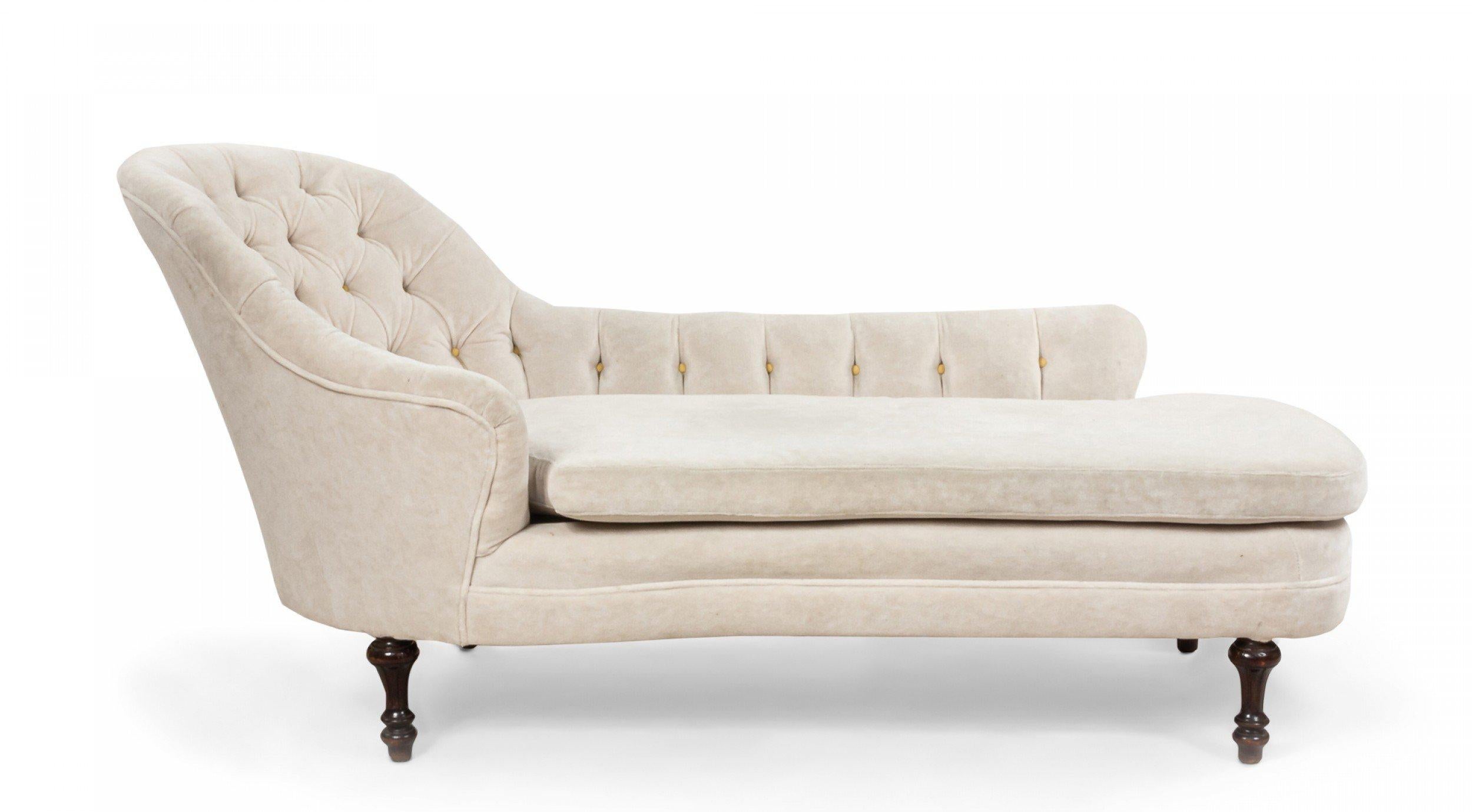 French Victorian style white velvet button tufted chaise lounge with elongated back arm and dark brown turned fluted legs.