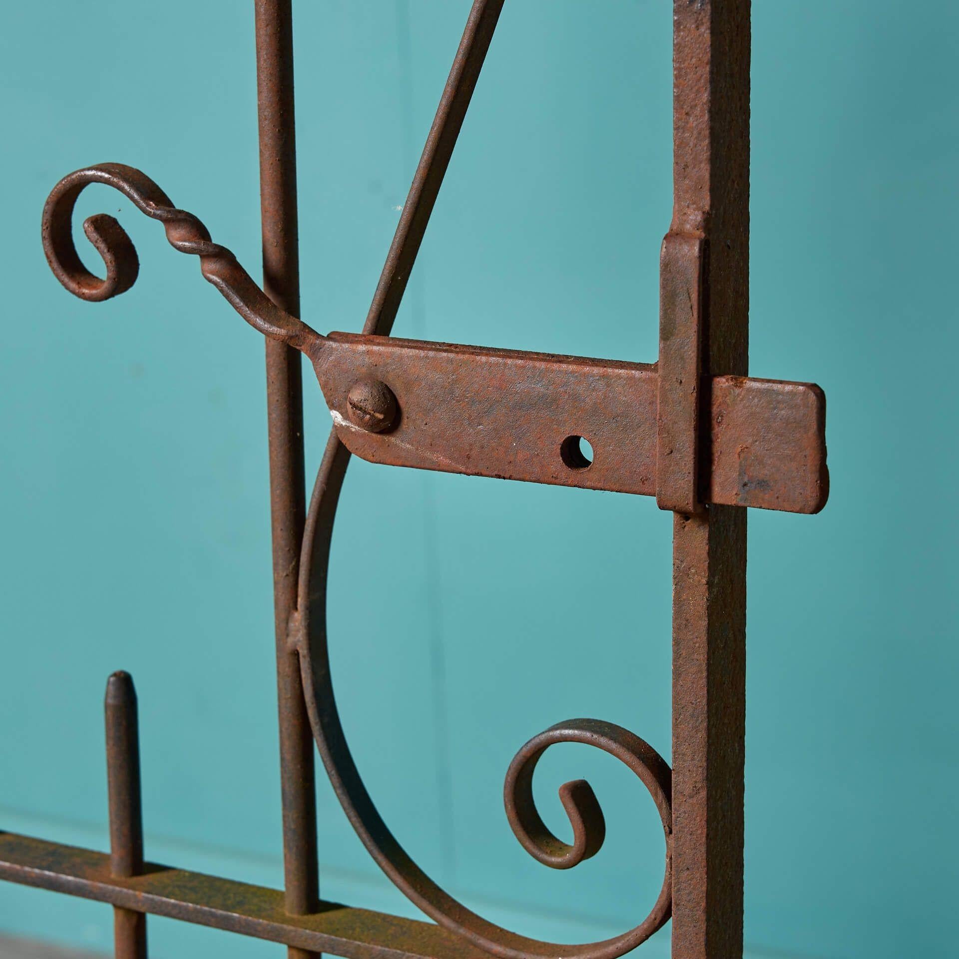 A reclaimed Victorian style wrought iron side gate, originating from 1930s England. This large-scale garden gate is a beautiful addition to properties period and modern with its simple design and timeless handcrafted scrollwork. Comes complete with