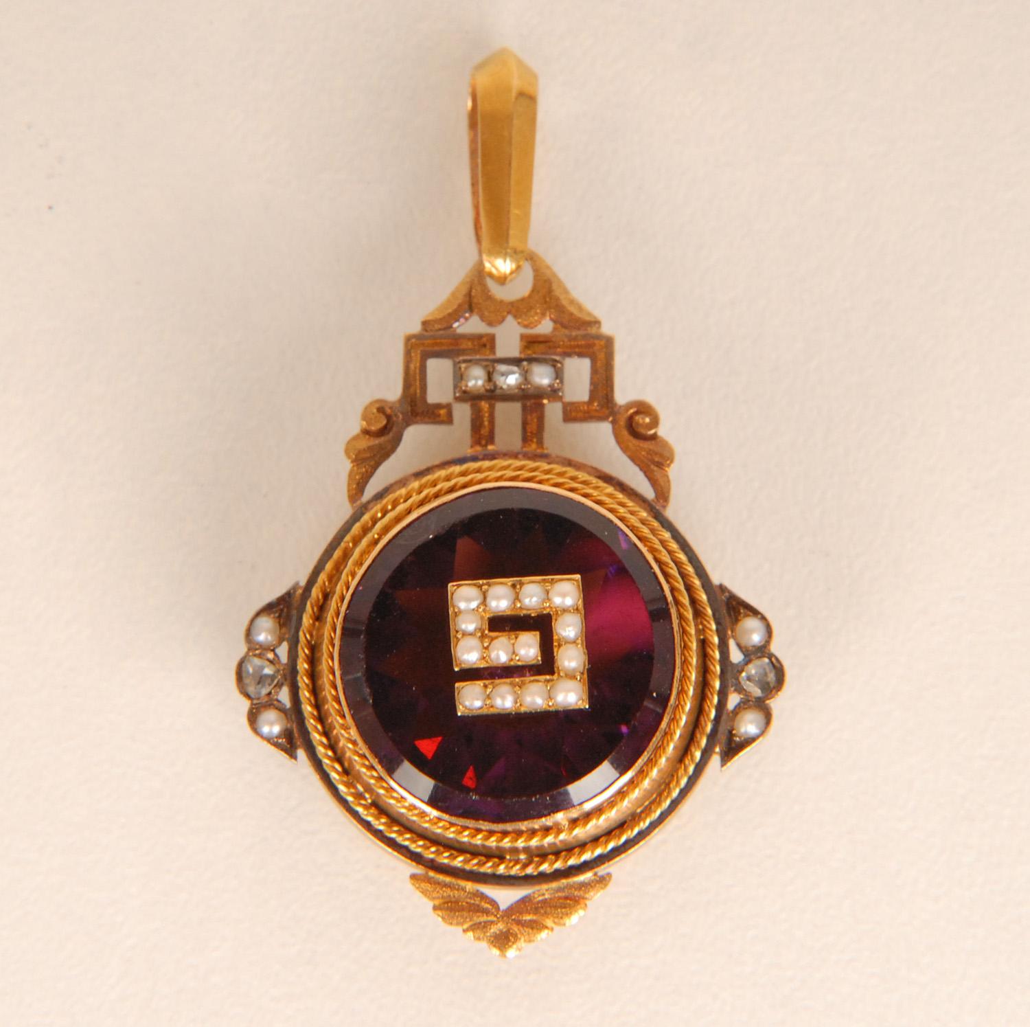Antique 19th century 18K gold sweetheart locket pendant with purple glass paste and natural certified diamonds and pearls
In the center of the purple glass amethyst the letter G or a 9 in natural seedpearls
Material: 18K yellow Gold, Old mine cut