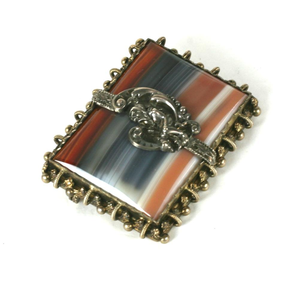 Victorian Swiss Agate Brooch from the Black Forest region decorated with a forest Gnome motif. Wonderfully striated agate is set in an ornate gilt silver setting with the forest gnome in silver set over it. Swiss circa 1900. 
Excellent condition