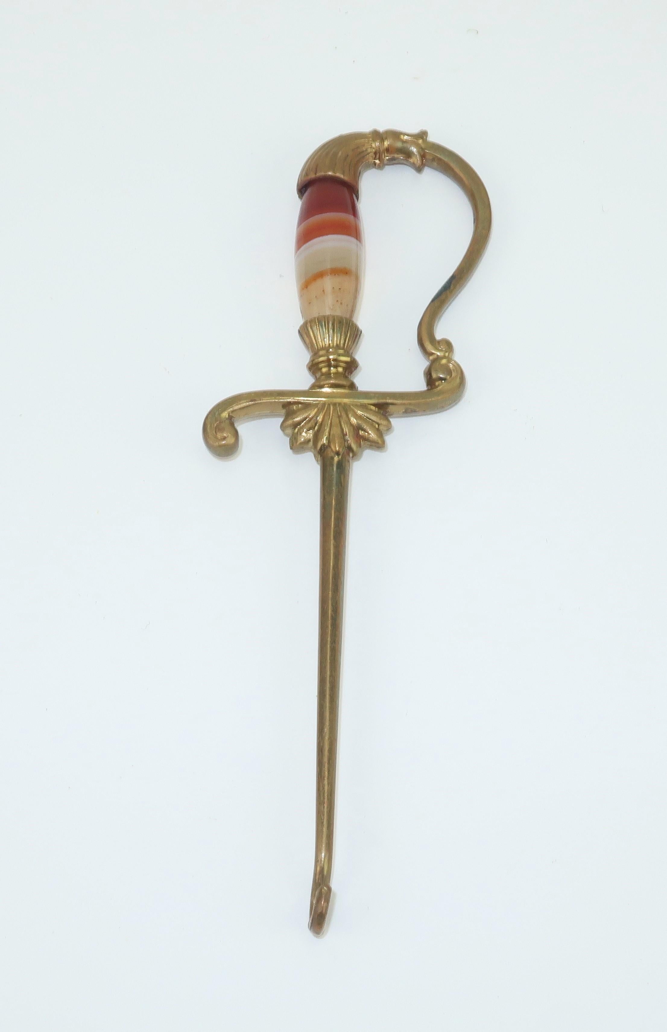 Victorian era brass button hook in the form of an ornate sword with a polished agate handle.  Perfect accessory for your favorite swashbuckler!  No maker's mark though well made with quality details.
CONDITION
Good condition though there is a spot