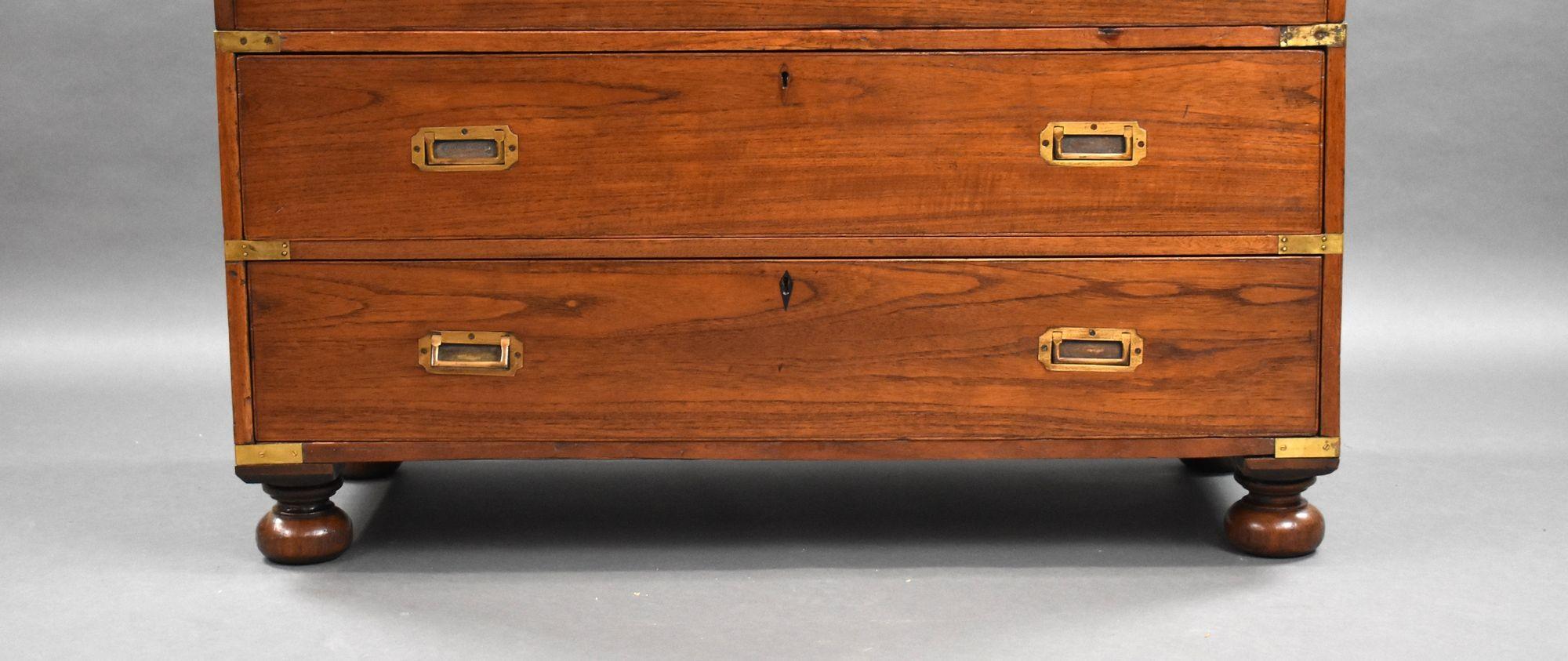 In vendita c'è una cassettiera vittoriana in teak di buona qualità, con cassetto superiore che si apre su un interno attrezzato e tre cassetti sottostanti, ciascuno con maniglie in ottone incastonate. La cassapanca si divide in due metà ed è