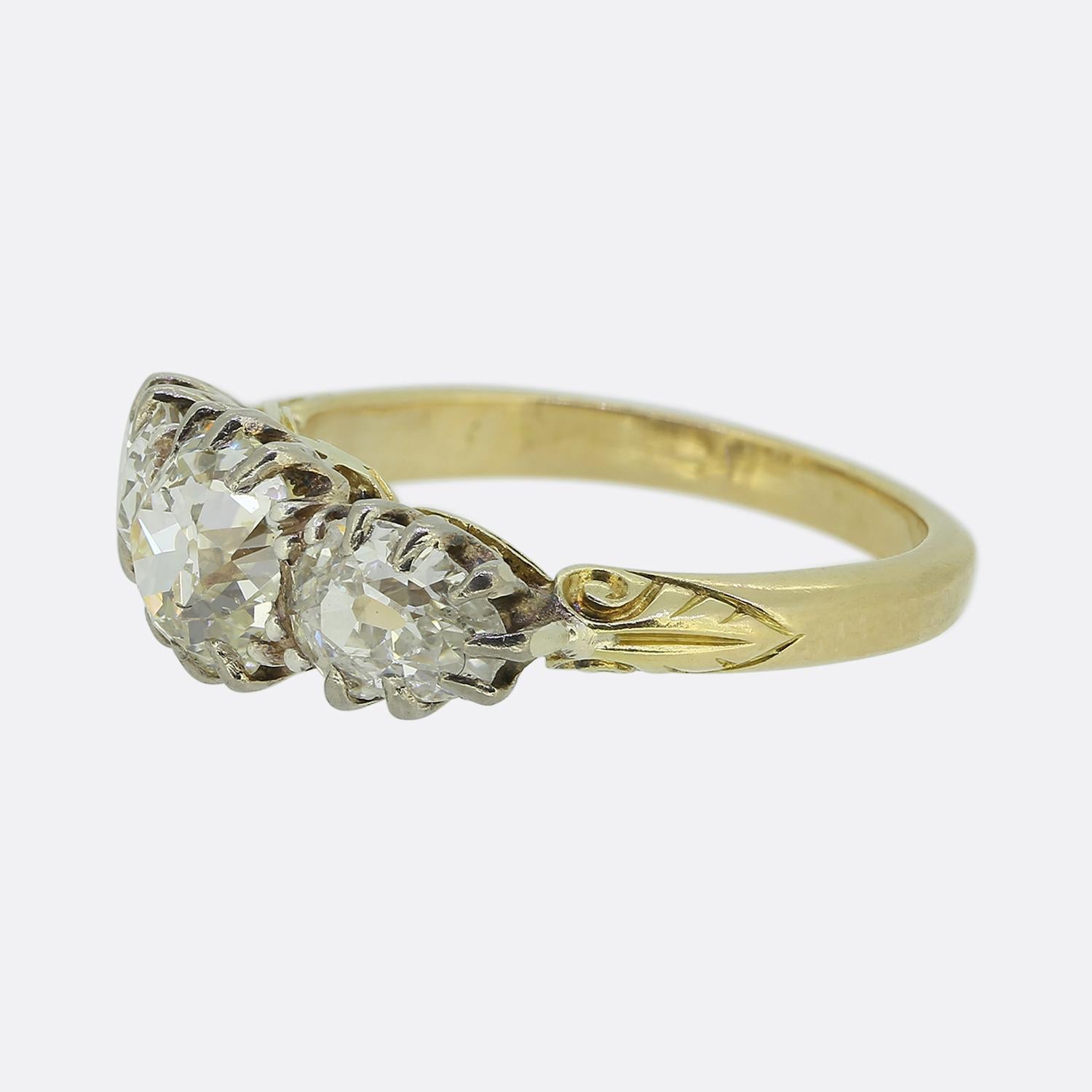 Nous avons ici une charmante bague à trois pierres en diamant datant de l'époque victorienne. Au centre de la face, nous trouvons une mine ancienne à facettes rondes, légèrement surélevée dans une monture à six griffes. Cette pierre principale est
