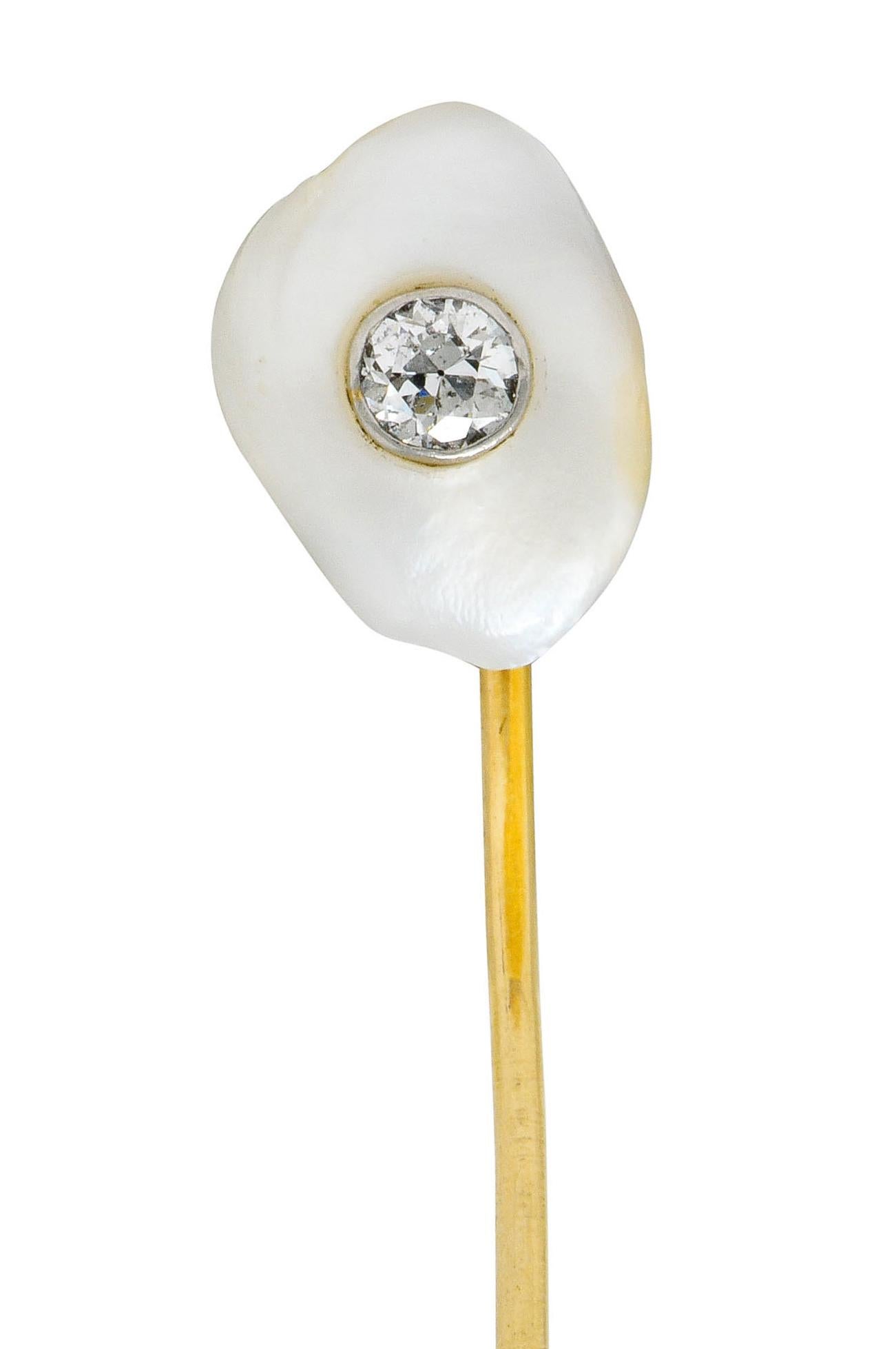 Featuring an amorphous baroque pearl with strong white body color, a slightly silver overtone, and an excellent luster

Inset with a transitional diamond, bezel set in platinum, weighing approximately 0.20 carat; eye-clean and white

Completed by an