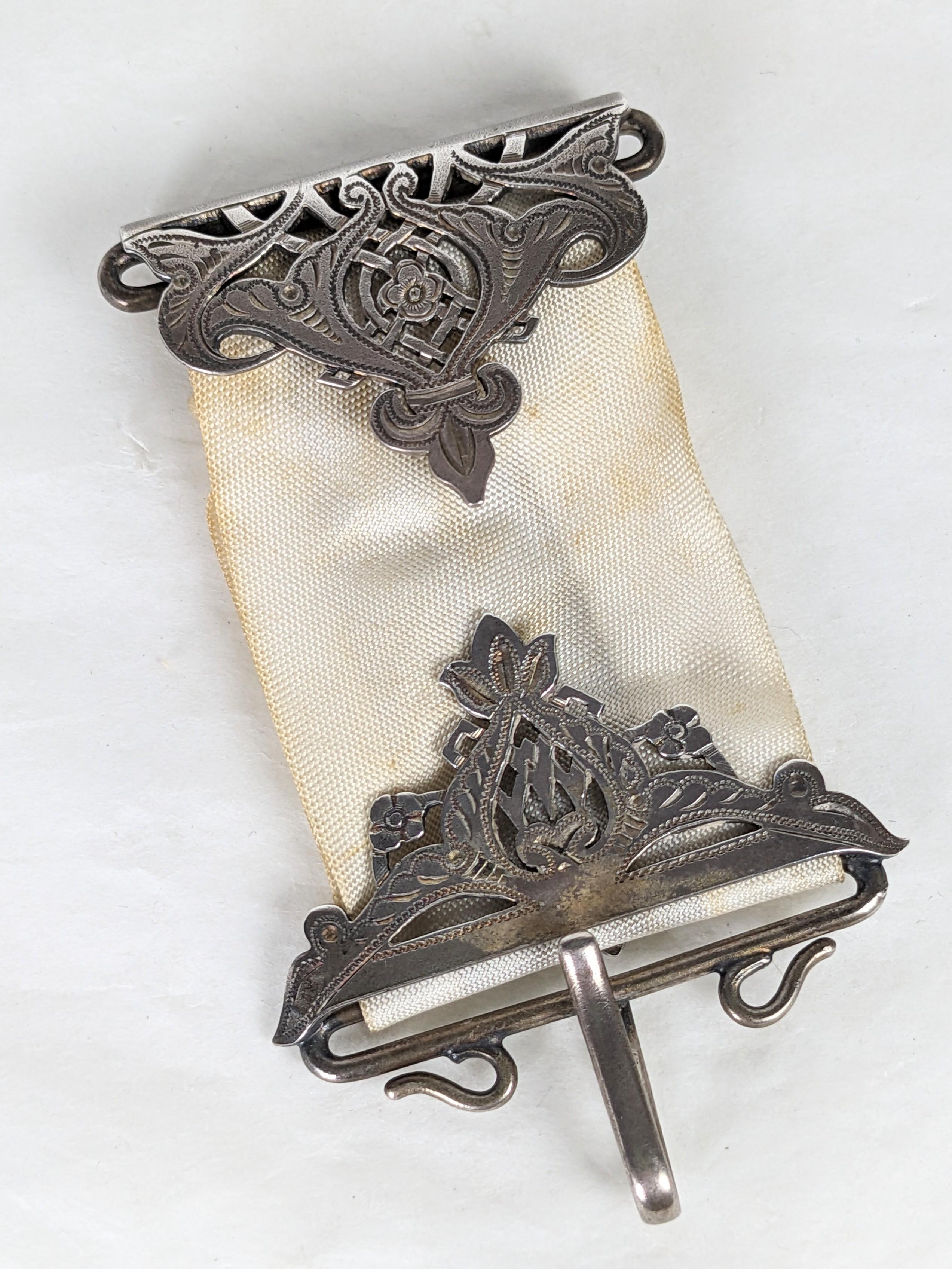 Viktorianische Tiffany Sterling Chatelaine aus dem späten 19. Jahrhundert. Verziert mit durchbrochenen Motiven aus Sterlingsilber mit einem zentralen Haken am Boden und 4 seitlichen Schlaufen zum Aufhängen von Utensilien an Ketten. Schwerer