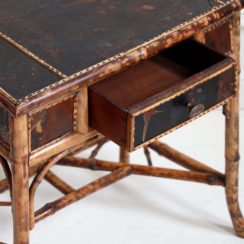 A charming tiger bamboo and lacquered writing table, a rare example of 19th-century Anglo-Japanese style capturing the Victorian fascination with East Asian aesthetics. Crafted from tiger bamboo, known for its distinctive dark markings, the desk
