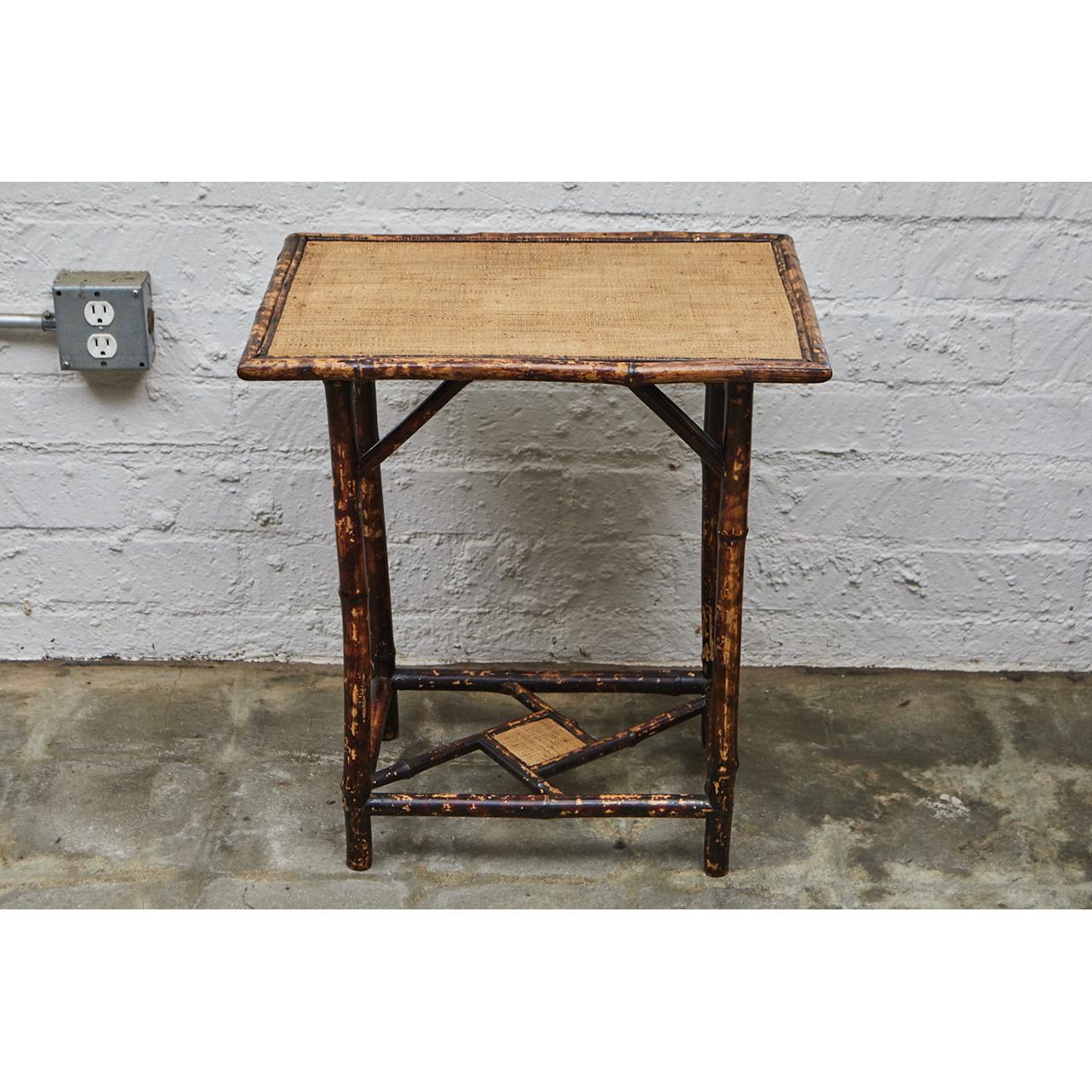This Victorian side table is made of tiger bamboo with newly re-surfaced waxed raffia matting. The table has diagonal supports and a diamond detail in the stretcher pattern. The legs have been reinforced with dowels for increased sturdiness. We have