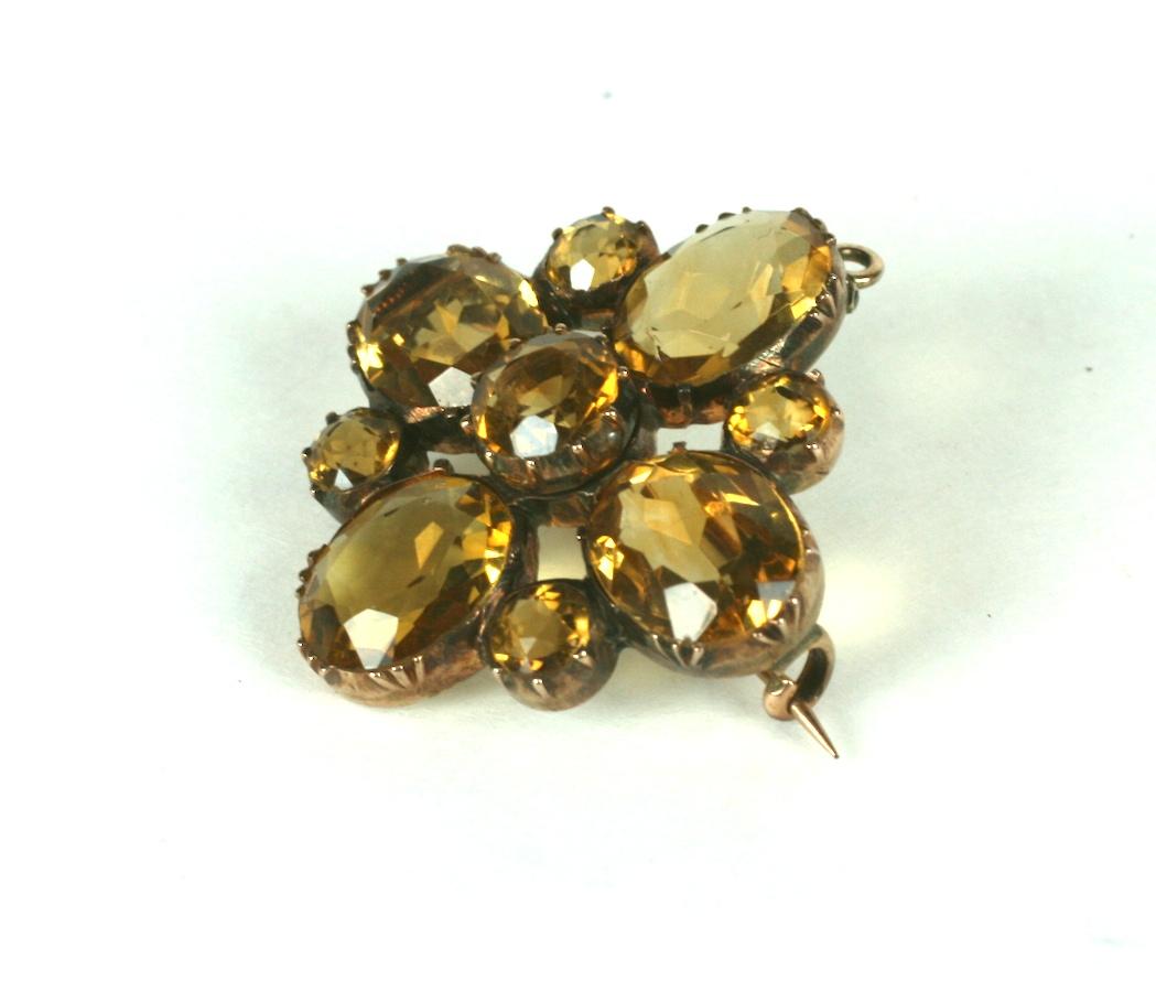 Victorian Topaz Pendant Brooch set in 10k gold. Simple, elegant design of oval and round sherry colored topazes set into almost invisible crown settings. Behind, a loop on a hinge hides a hidden bale which creates a pendant option. 
Stones are much