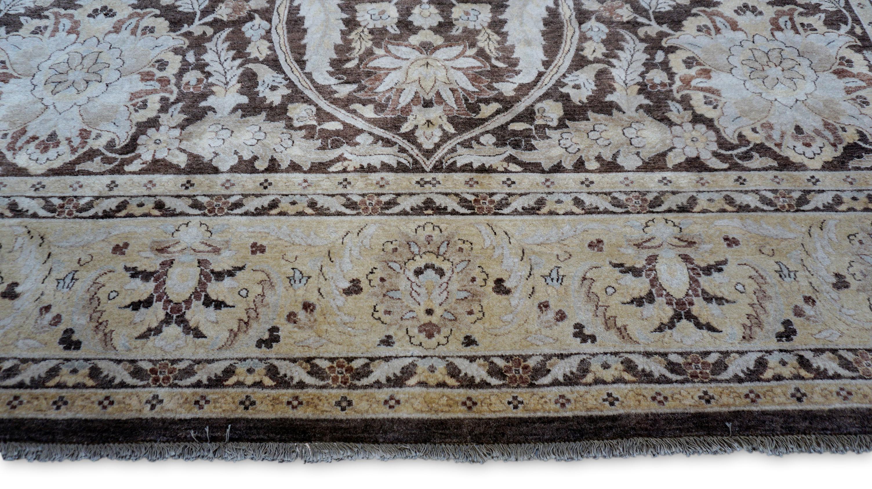Esta alfombra de lana anudada a mano muestra un diseño de medallón floral de inspiración tradicional, intrincadamente tejido con ricos detalles. El cálido campo marrón sirve de telón de fondo perfecto para un elaborado conjunto de motivos florales