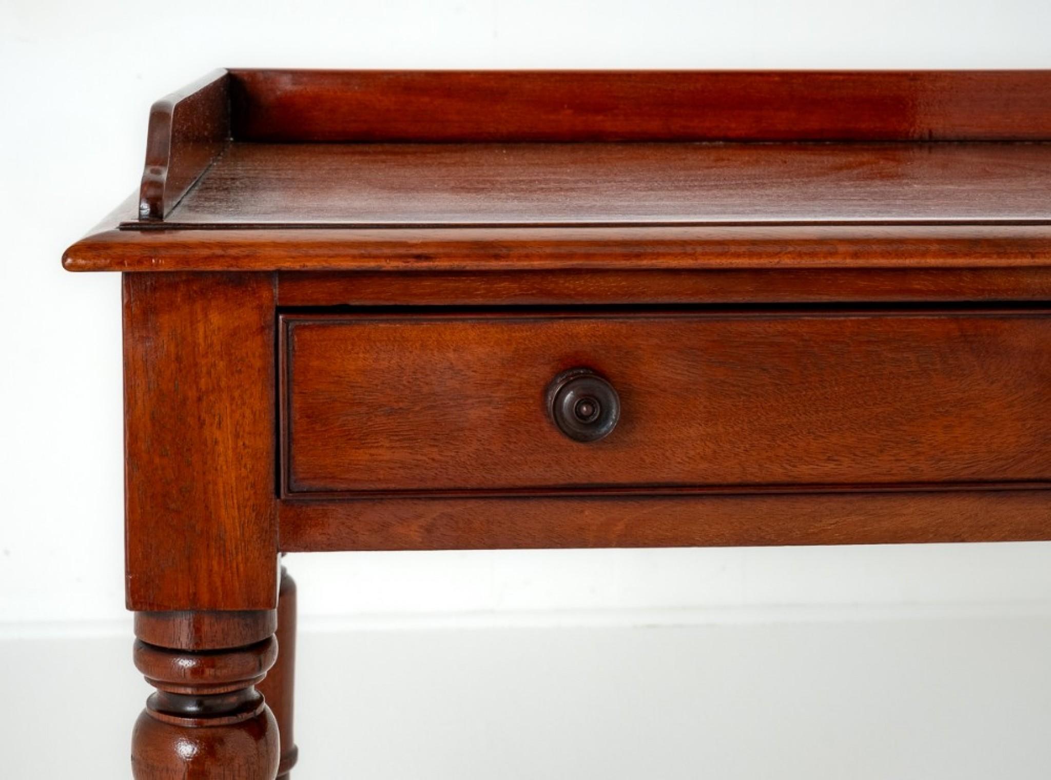 Victorian Mahogany Tray Top Side Table.
This Side Table is Raised upon Crisply Ring Turned Legs. Circa 1860
Featuring 2 Mahogany Lined Drawers With Ring Turned Knobs.
The Top of the Side Table Having a Small Raised Gallery.
Presented in good