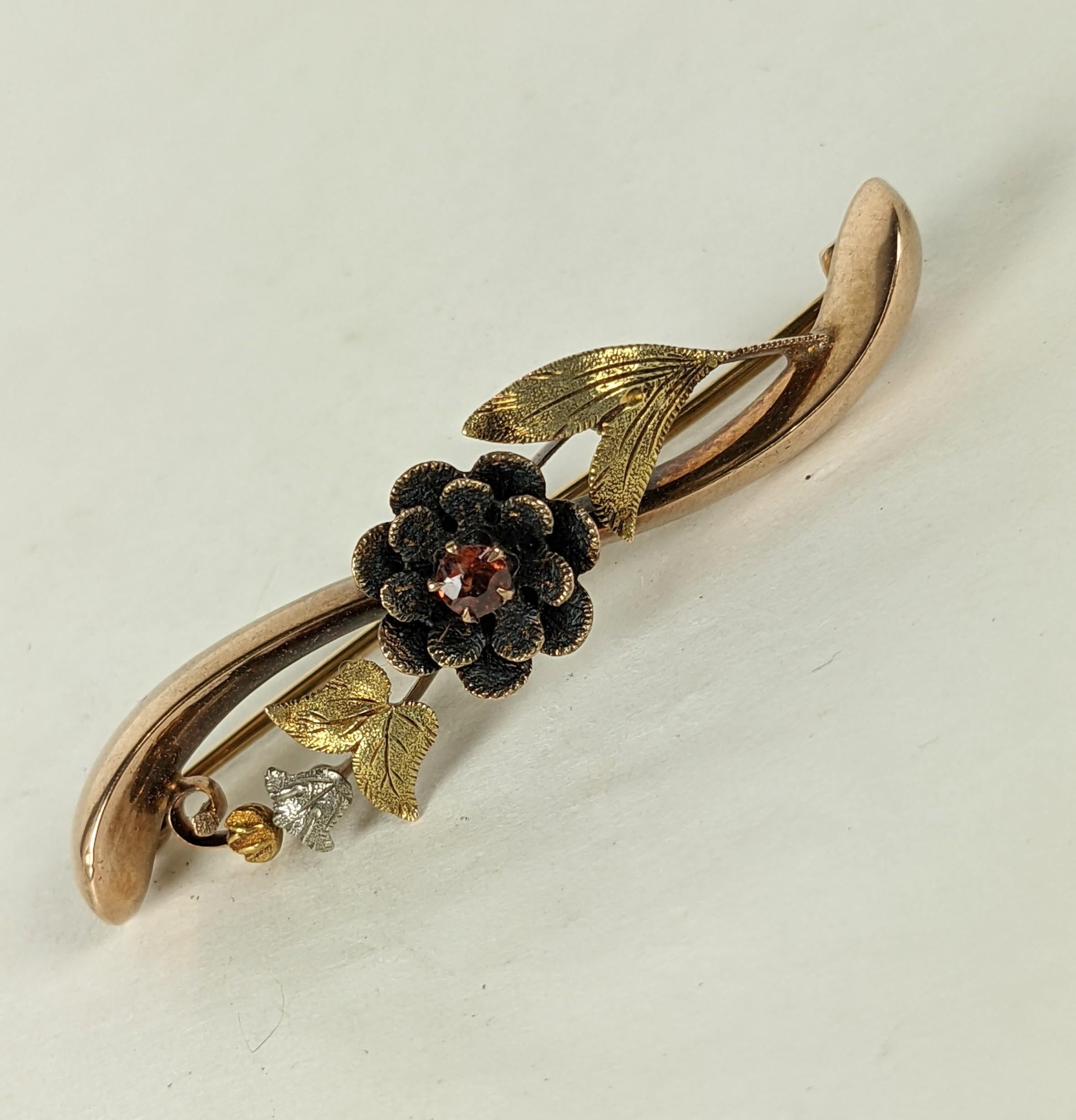 Victorian Tri Color Gold Floral Bar Pin from the 19th Century. Lovely 14k gold brooch with etched flower petals and leaves in green, yellow and red gold detailing. Garnet centered flower. 1870's USA.  1.75