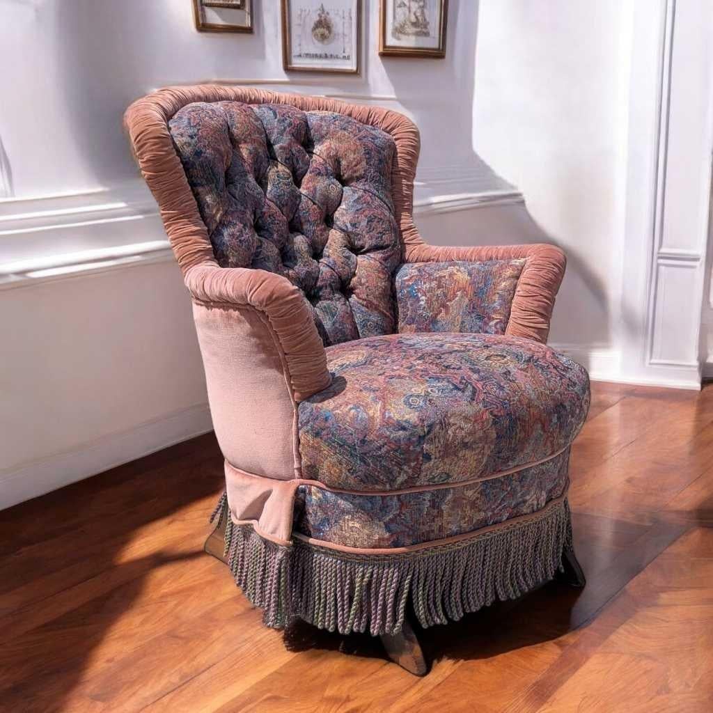 Una sedia a dondolo vittoriana stravagante e romantica, rivestita su misura in un morbido tessuto di velluto arrossato e floreale con una gonna decorativa a frange. Questo pezzo d'antiquariato è caratterizzato da uno schienale alto e trapuntato,