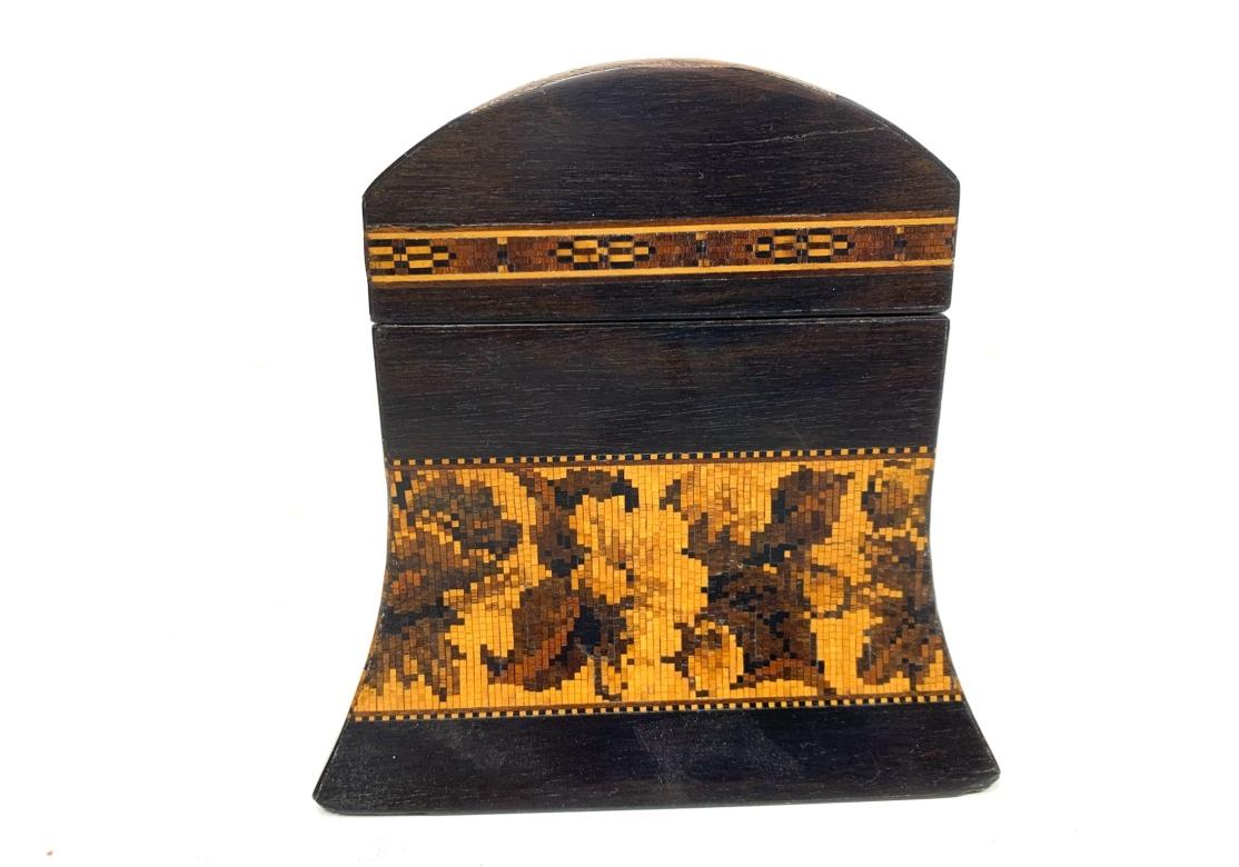 Antigua caja de loza Tunbridge con un exterior bellamente taraceado con bordes de rosas florales, forma entallada y parte superior abovedada con incrustaciones de mosaico de una granja. La tapa abatible se abre para mostrar pequeños separadores