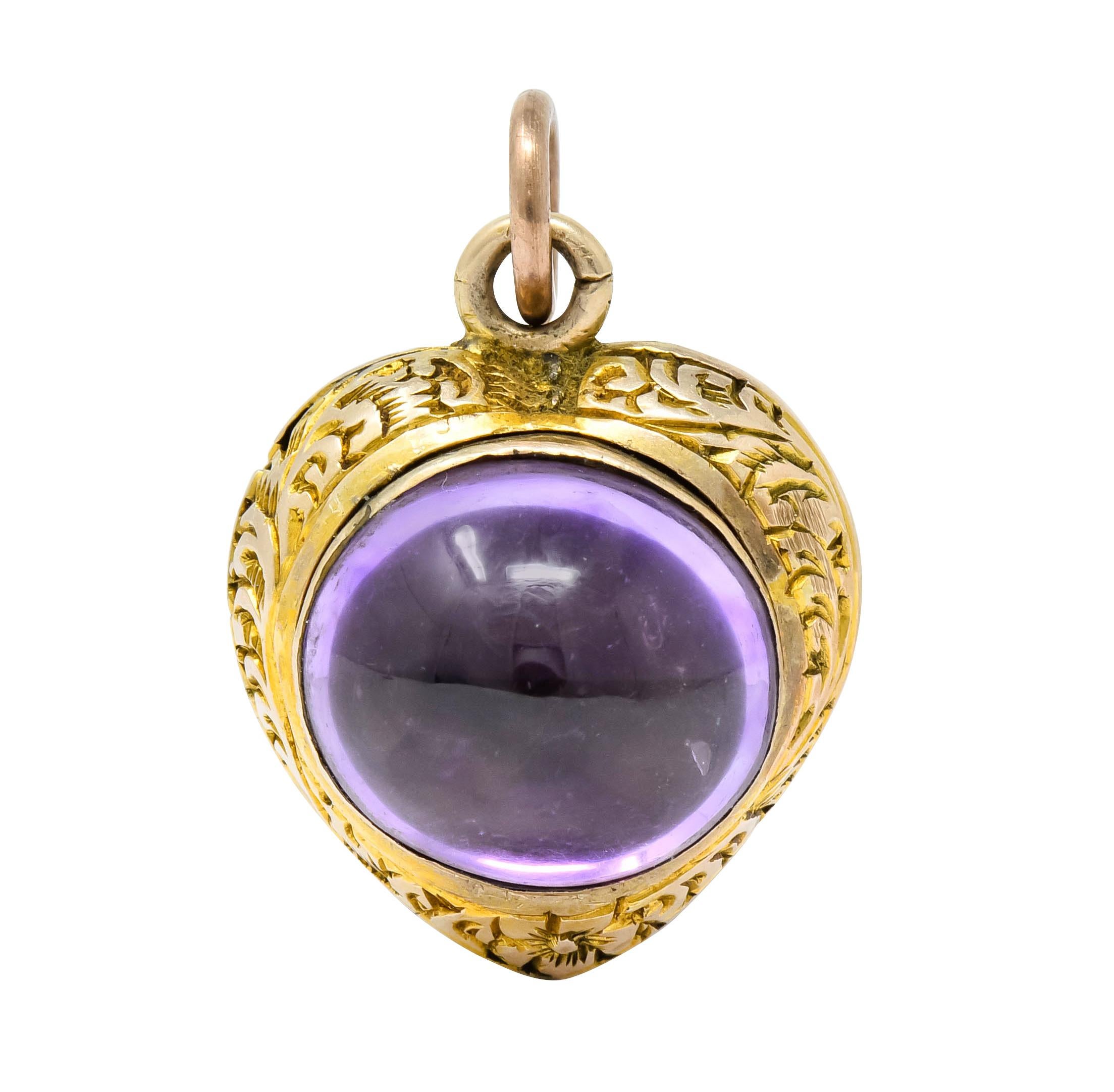 Charm designed as a heart deeply engraved with foliate motif throughout

One side bezel set with oval cabochon purple foil-backed stone measuring approximately 10.5 x 9.2 mm

Opposite side features three bezel set turquoise cabochon measuring