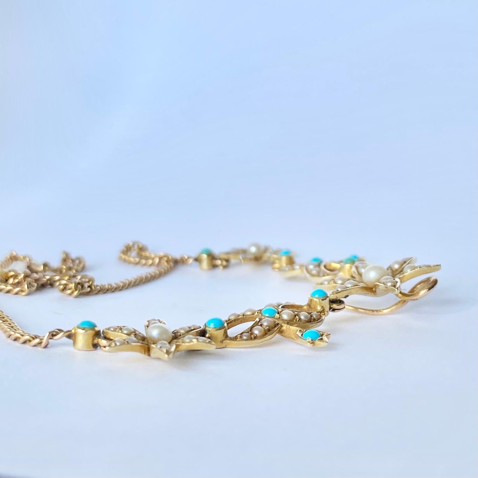 The chain on this necklace is a curb link and the main detail includes a flower and leaf design. There are turquoise and pearls set within this 18ct gold. 

Length: 41cm
Widest Point: 20cm

Weight: 12.2g