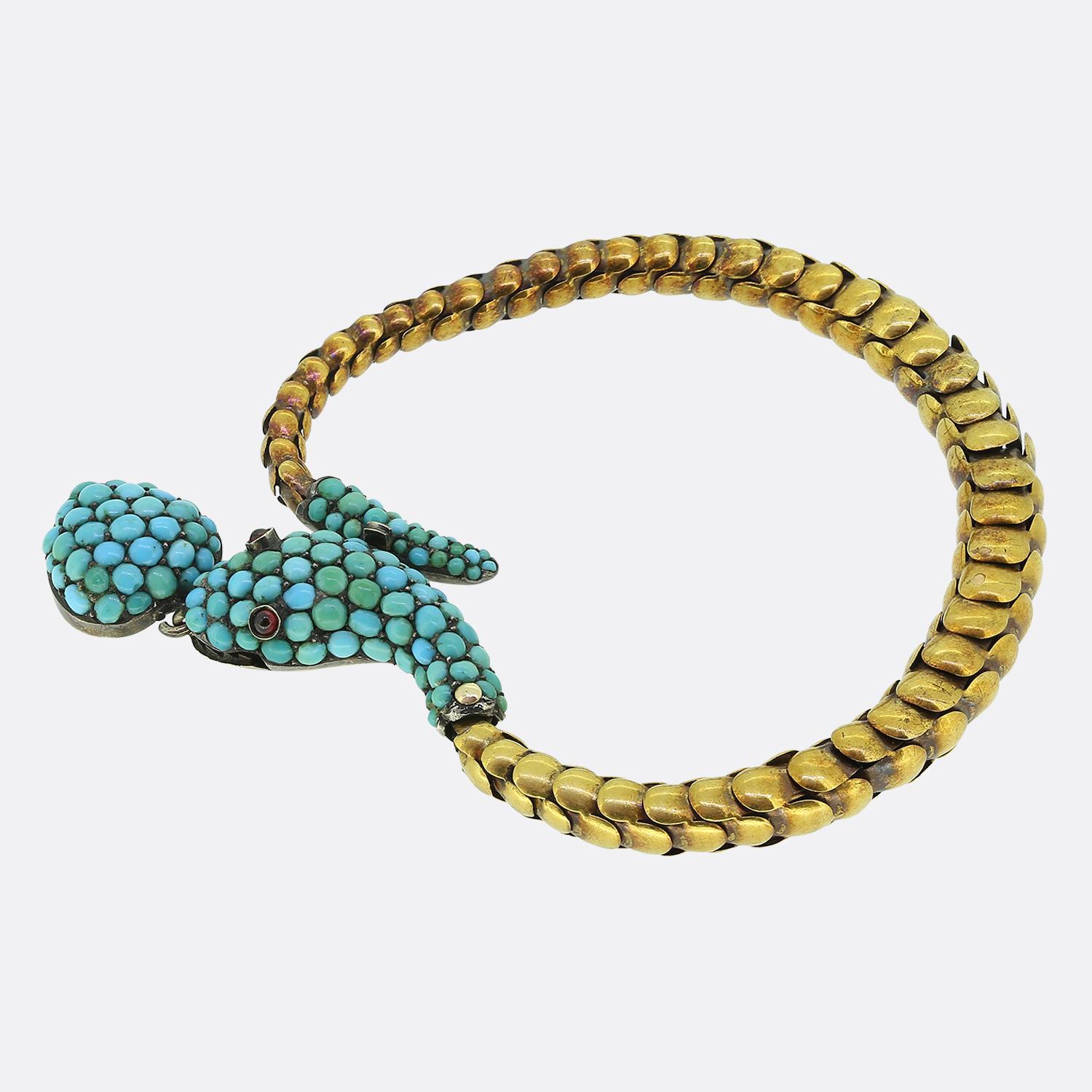 Hier haben wir ein auffälliges Armband aus der viktorianischen Ära. Dieses antike Stück wurde aus reichem 18-karätigem Gelbgold gefertigt und bildet ein flexibles, schuppenartiges Band, das sich anmutig um das Handgelenk legt. Das Armband zeigt ein