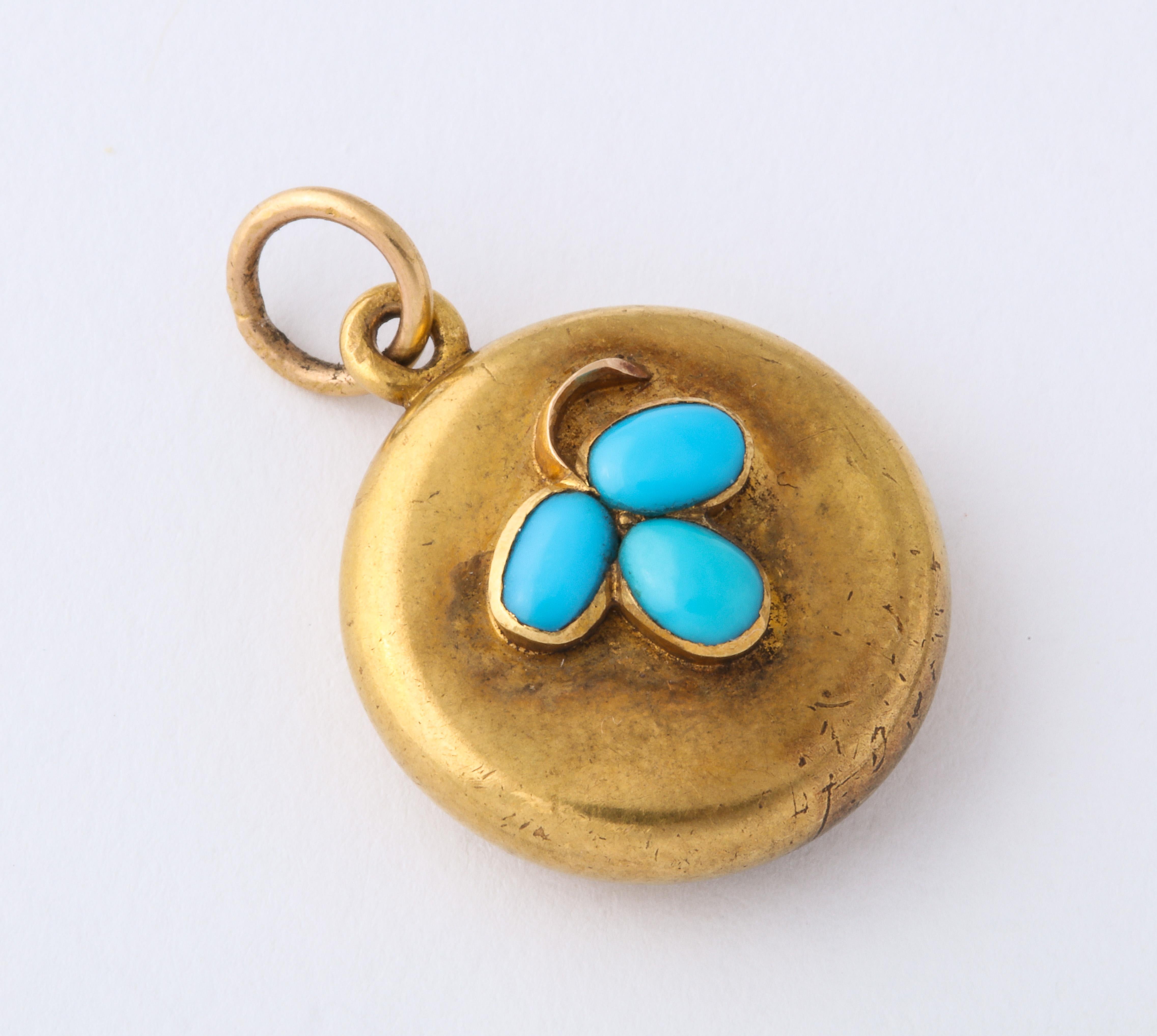 Small yellow gold locket with three turquoise on the front creating a clover with the addition of the small yellow gold stem. Back has collet fitted glass compartment. Circa 1870.