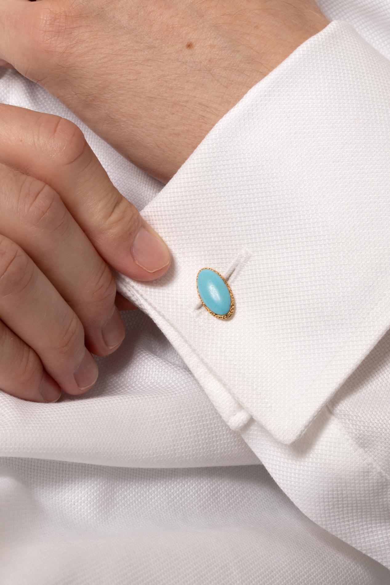 Diese viktorianischen Manschettenknöpfe versprühen klassischen Charme. Ein Paar Türkise im Marquise-Cabochon-Schliff sind zart von 18 Karat Gelbgold umgeben. Die goldene Umrandung weist ein kompliziertes, von Hand eingraviertes Muster auf. Die