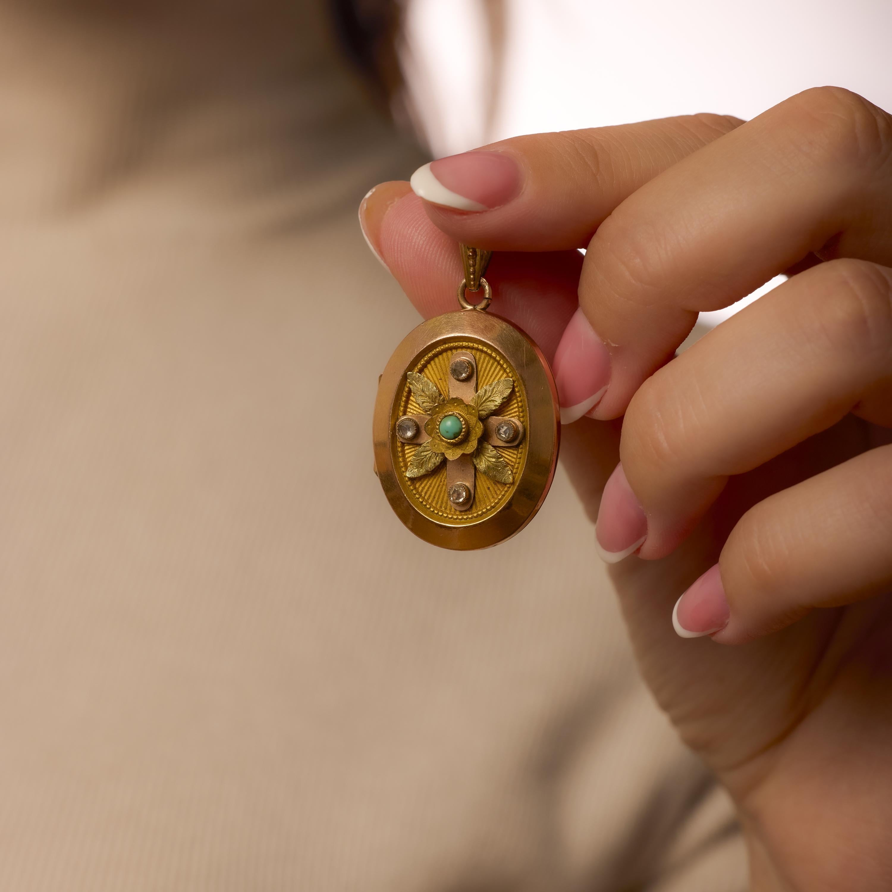 This antique 18k yellow and rose gold pendant highlights a vivid turquoise cabochon accented by delicate single cut diamonds in an ornate Victorian design.