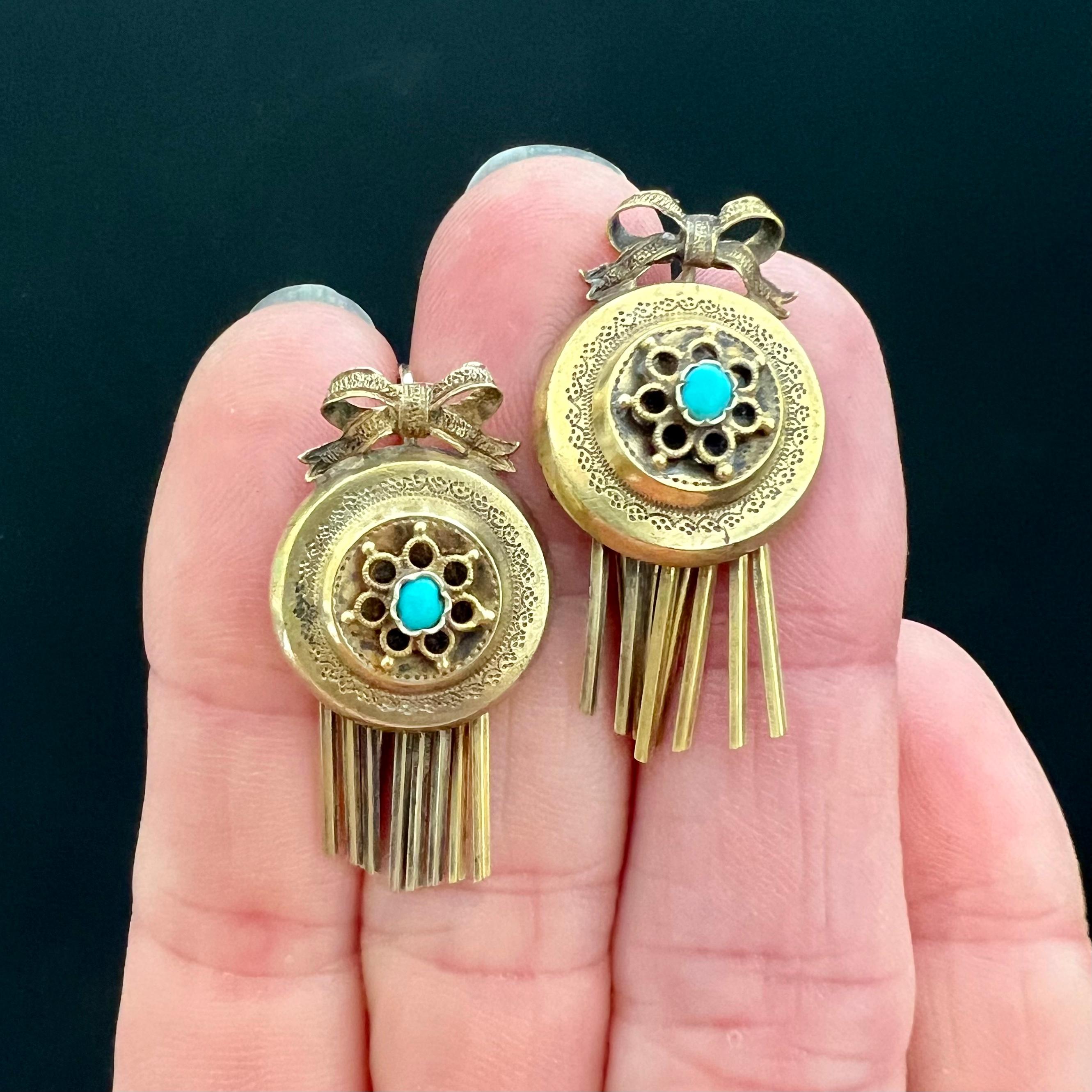 These antique Victorian earrings are perfectly accented with delicate engraved work, bright blue turquoise, and playfully dangling flat bars at the bottom.  

A beautiful bow frame adorns these earrings at the top and at the base of each earring are