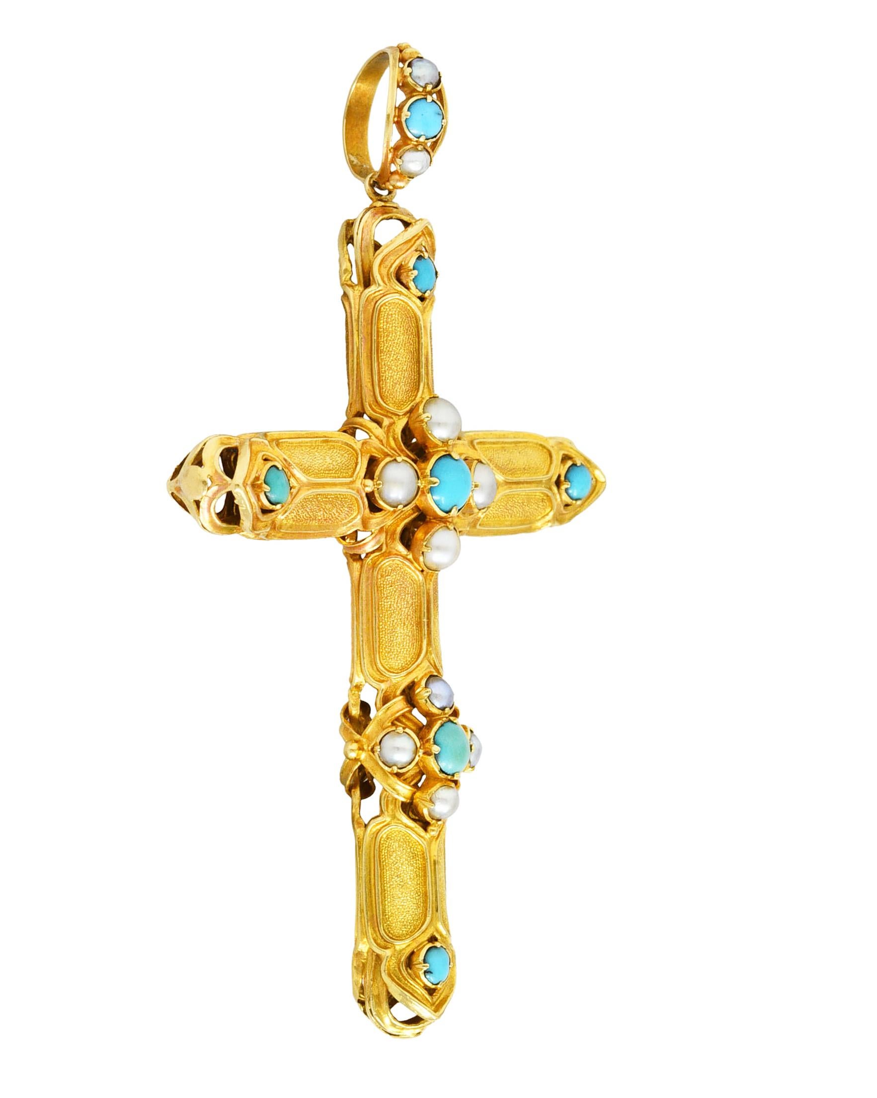 Designed as a pierced cross form with gothic tracery motif panels of textured gold recesses. Featuring 2.5 to 5.0 mm round turquoise cabochons prong set at cardinal points, center, and bale. Opaque robin's egg blue to greenish blue in color with