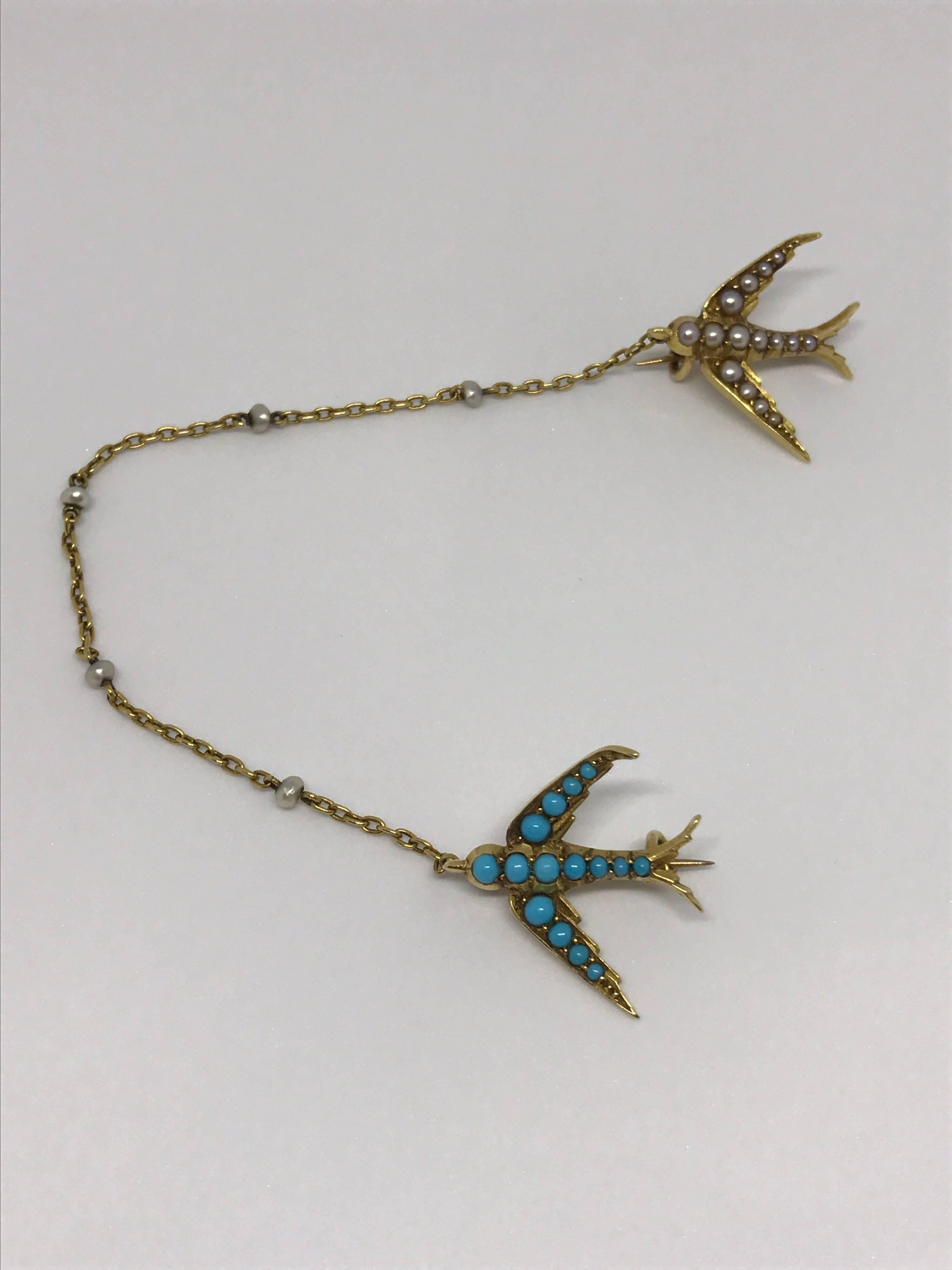 A pair of late Victorian split pearl and cabochon turquoise swallow brooch, designed as two swallows in flight, one encrusted with turquoise cabochon and the other split pearls, both set in 15ct yellow gold with a seed pearl trace chain connected to