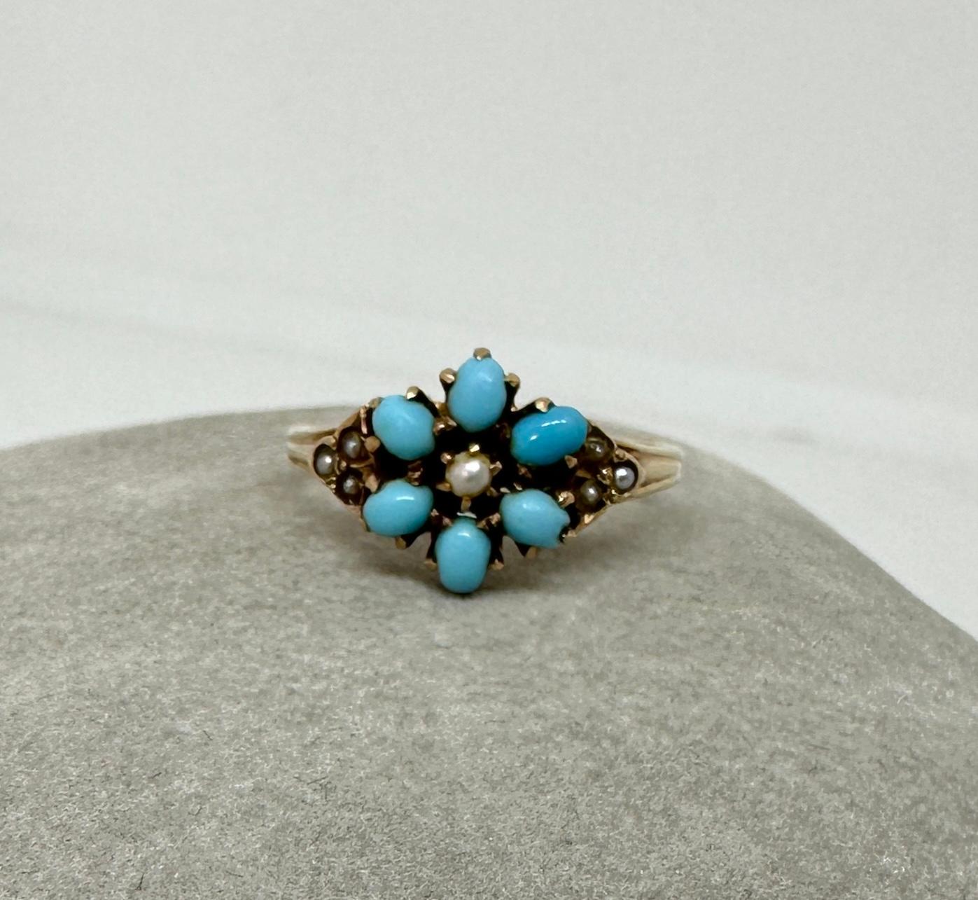 Cette bague victorienne ancienne, étonnante et si romantique, est ornée de six turquoises persanes et de perles dans un délicat motif floral. La combinaison des perles et de la turquoise dans cette magnifique bague est un véritable enchantement.  Il