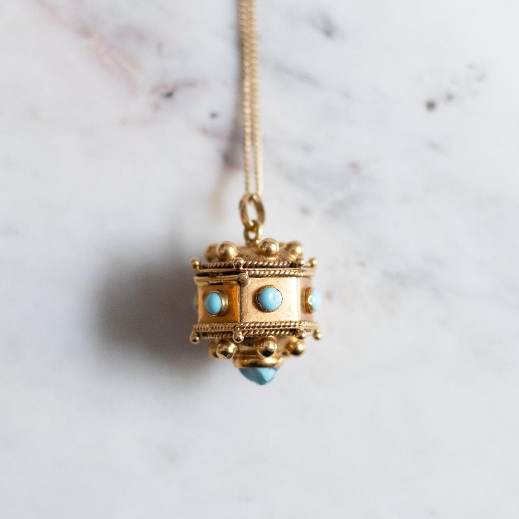 A Victorian turquoise pendant with dice in 18 karat yellow gold.

This beautiful and highly unusual pendant is designed as a domed hexagon, studded to each side and its underside with a cabochon turquoise  featuring ornate gold wirework edging and