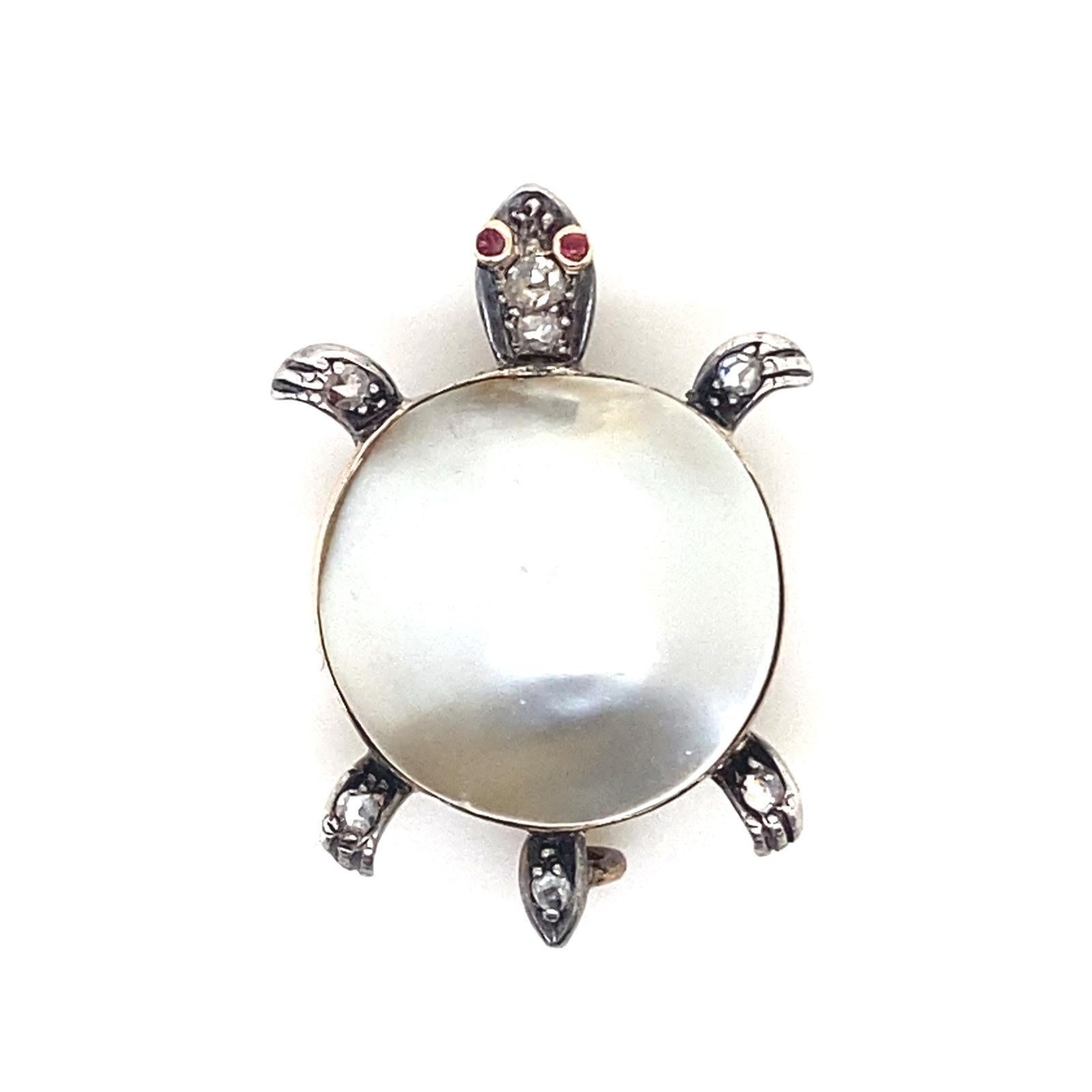 A Victorian Turtle Brooch in Yellow Gold and Silver set with Diamond and Ruby

This antique turtle pin brooch is highly collectible. Its shell comprises of a a mabe pearl set into yellow gold. His legs, tail and head are grain set in silver with old