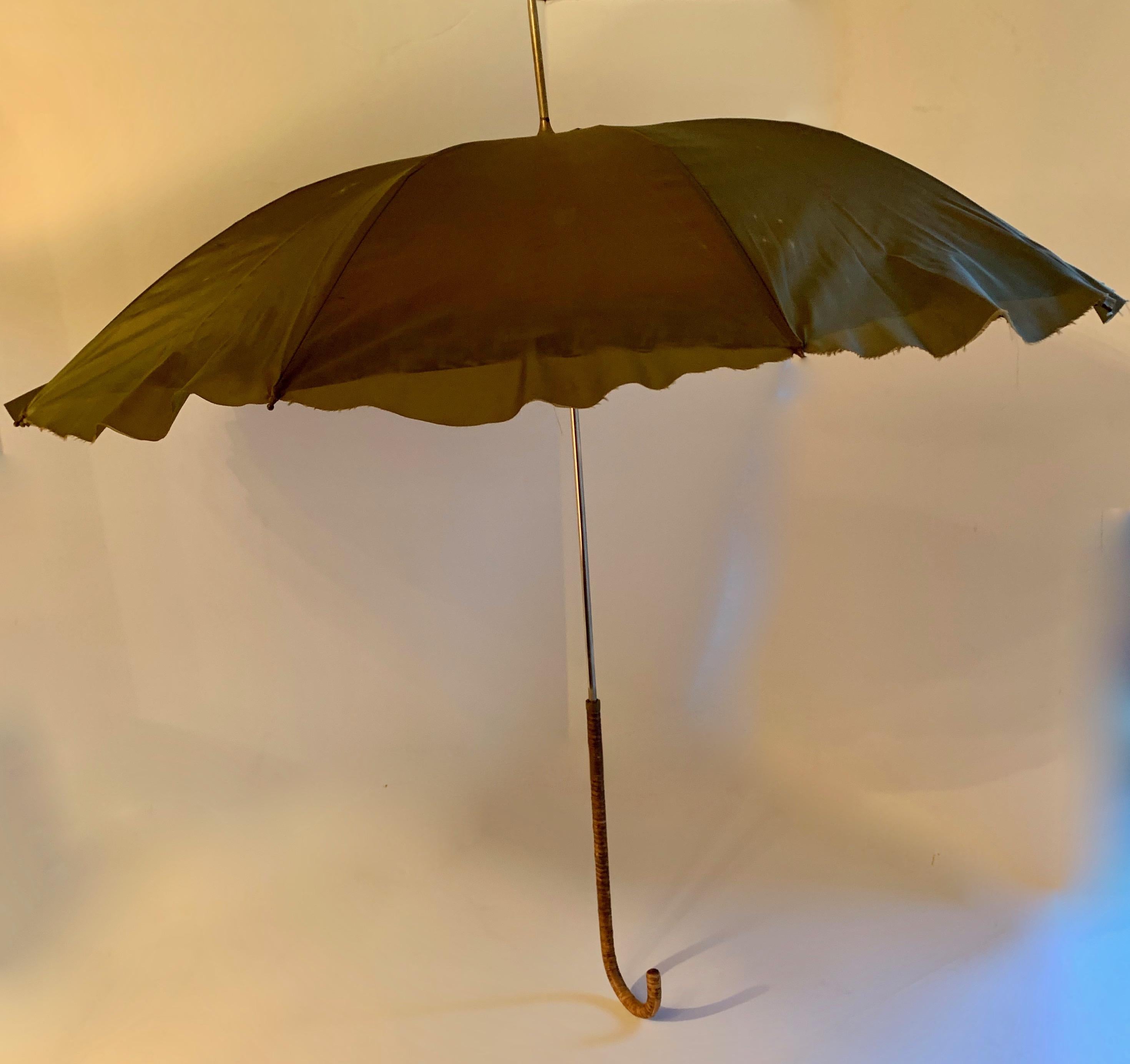 Victorian umbrella with cane handle - a unique and handsome piece, the umbrella is held in place with a 'snake' band. When open, the fabric is a melange of color and texture, with a raw edge. The handle is a beautiful woven cane... Very good vintage