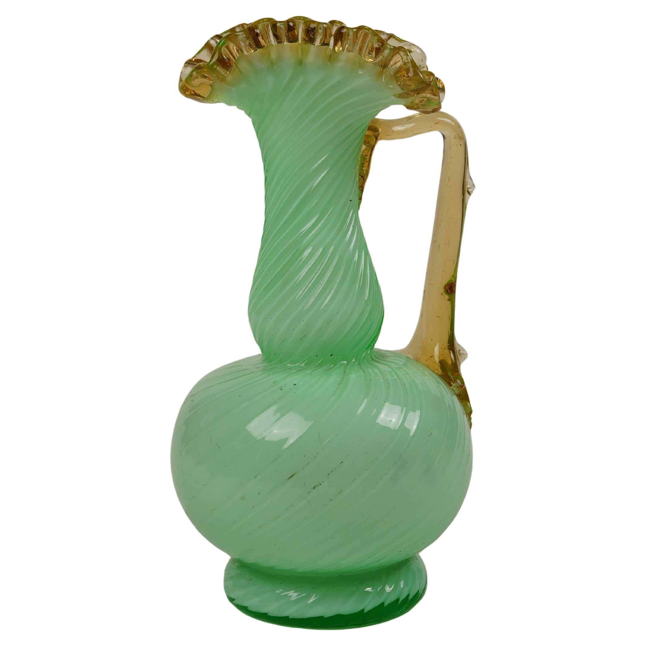 Exemple frappant de l'art du verre victorien du XIXe siècle, ce vase à aiguière vert uranium opalin allie une forme délicate à des détails décoratifs audacieux. Le corps est fabriqué en verre opalin vert lumineux avec un subtil motif tourbillonnant,