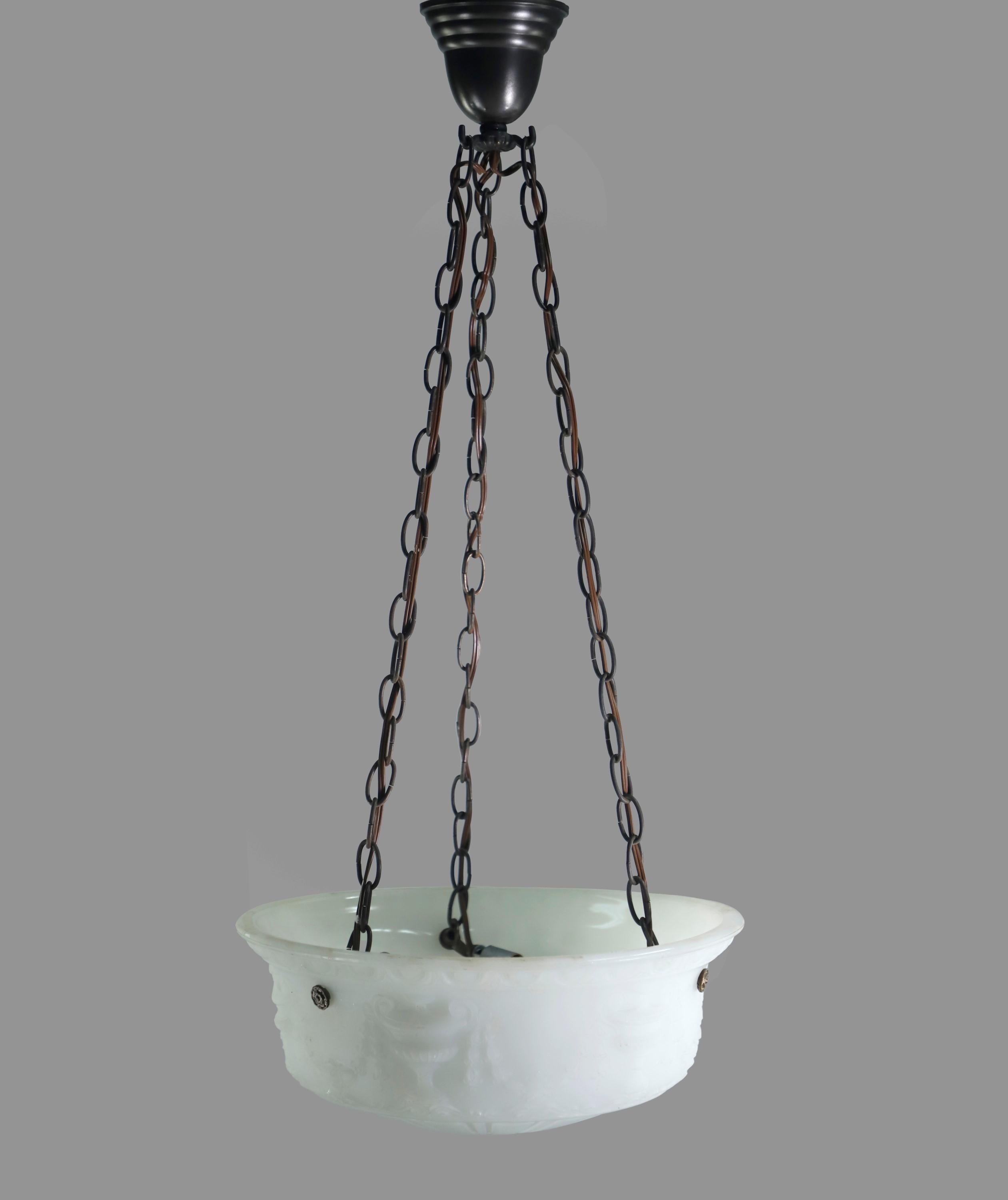 Early 20th Century cast white milk glass dish pendant light featuring urns, swags, and a Greek egg and dart design. Dish is suspended by three black finish chains from an original canopy. Cleaned and restored. Takes three candelabra light bulbs.
