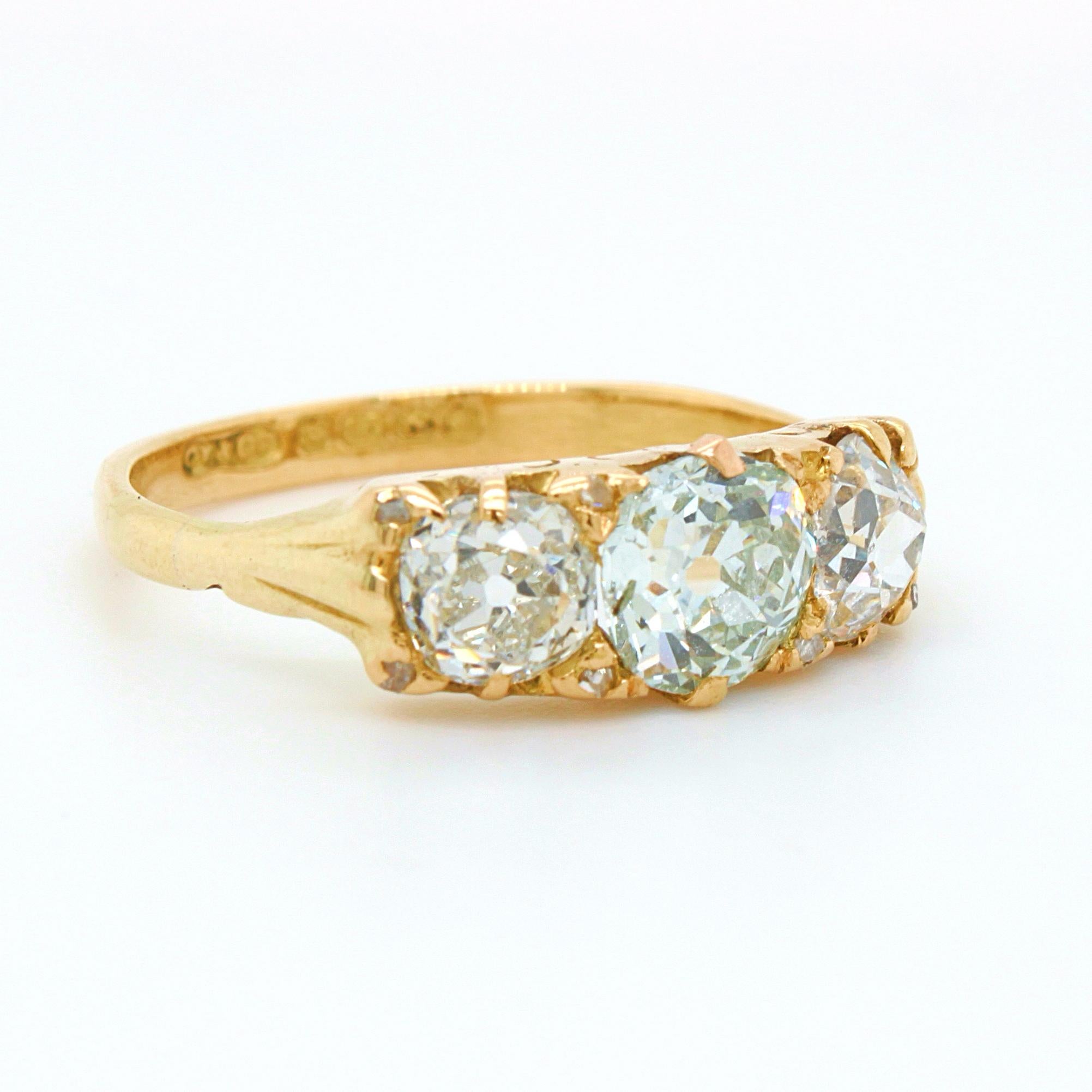 A Victorian three diamond ring in 18k yellow gold, ca. 1880s. The bigger centre stone out of the three is a very light green old European cut diamond weighing 0.88ct, accompanied by a GIA certificate, with no eye visible inclusions. The two side