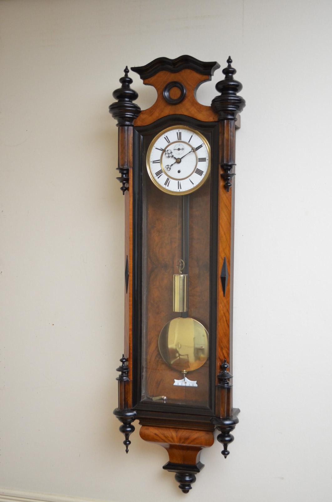 Sn2498 Victorian, figured walnut Vienna clock, having enamelled dial with Roman numerals, original hands and second dial (the seconds hand only takes 45 seconds to reach the 60 mark), all in walnut case with ebonized finials and canted corners with