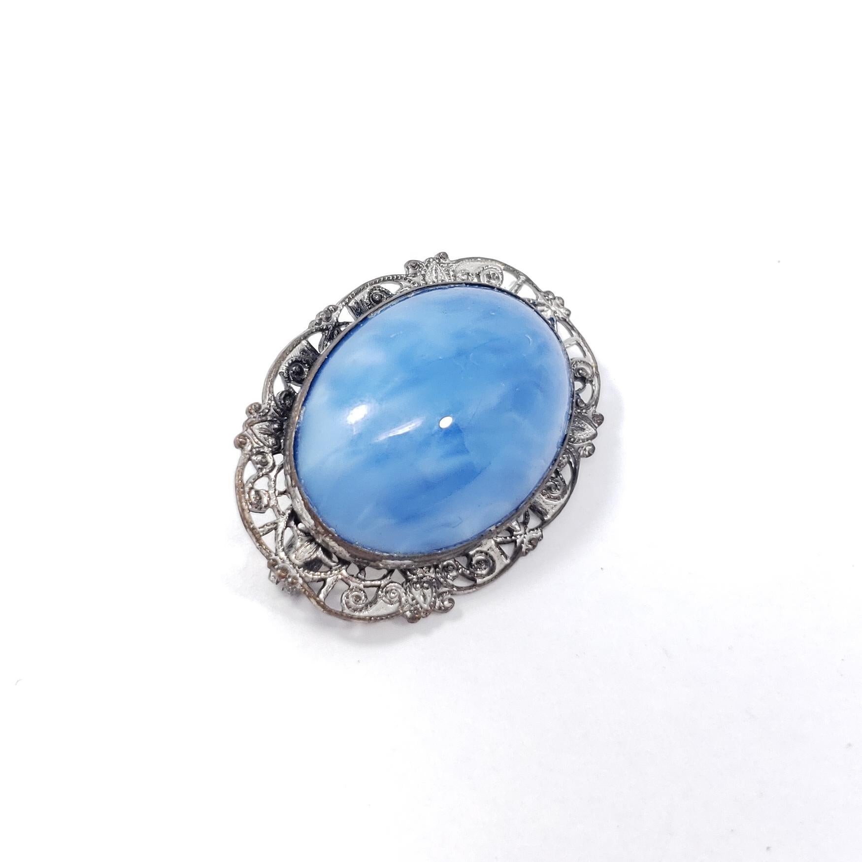 Victorian-era pin brooch, featuring a light-blue gemstone cabochon set in a decorative silver-tone bezel.