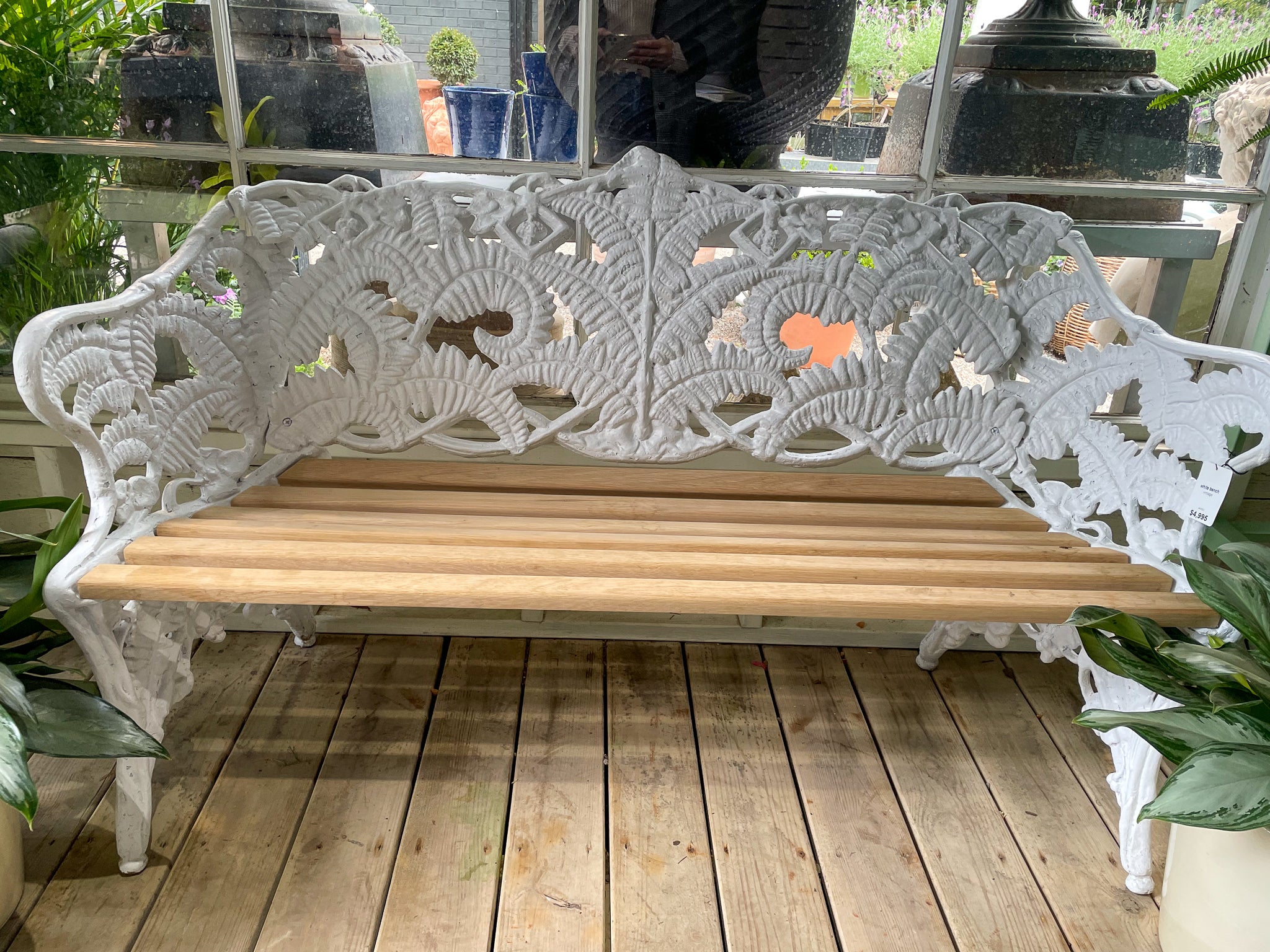 We presents for your consideration a Victorian cast iron garden bench. The bench includes white painted fern ornament to the barrel back, and a refinished wooden seat. The perfect addition to any traditional garden.