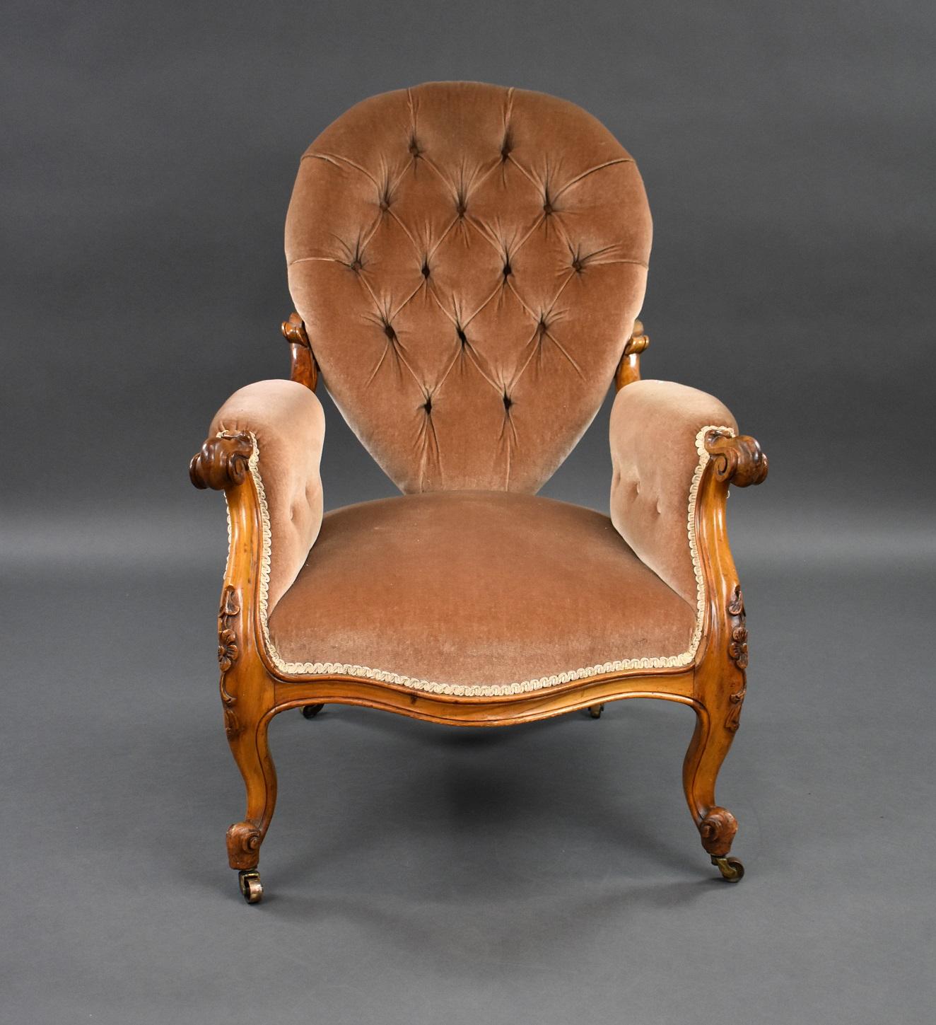 Victorian walnut armchair in good condition with buttoned pear drop shaped back with serpentine front, scroll arms standing on carved cabriole legs on castors. Structurally sound.