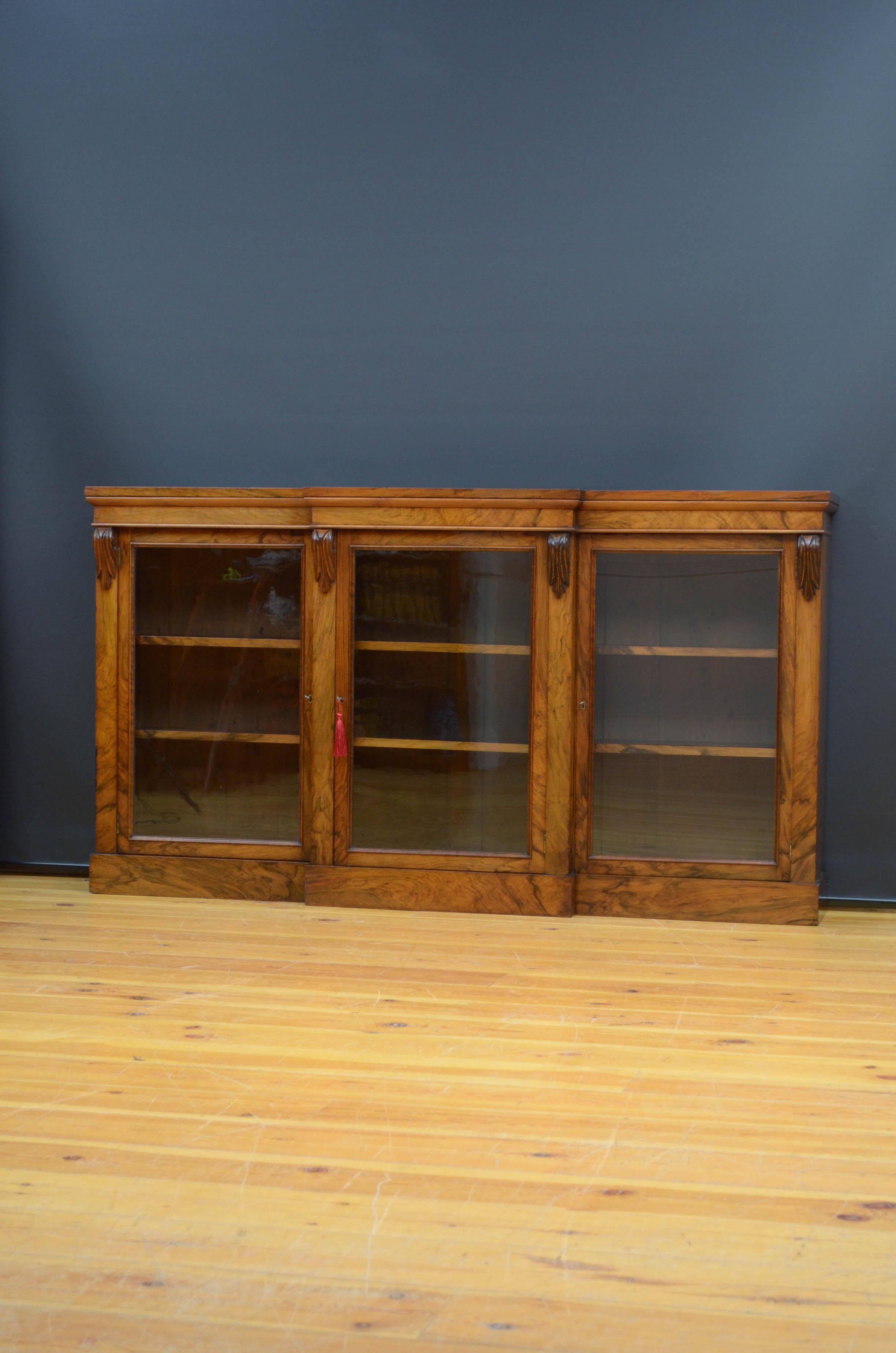 Sn5151 Victorian bookcase in walnut, having figured walnut top above a projecting glazed centre doors flanked by drop carvings and further glazed doors, all fitted with working locks and three keys and enclosing height adjustable shelves, standing