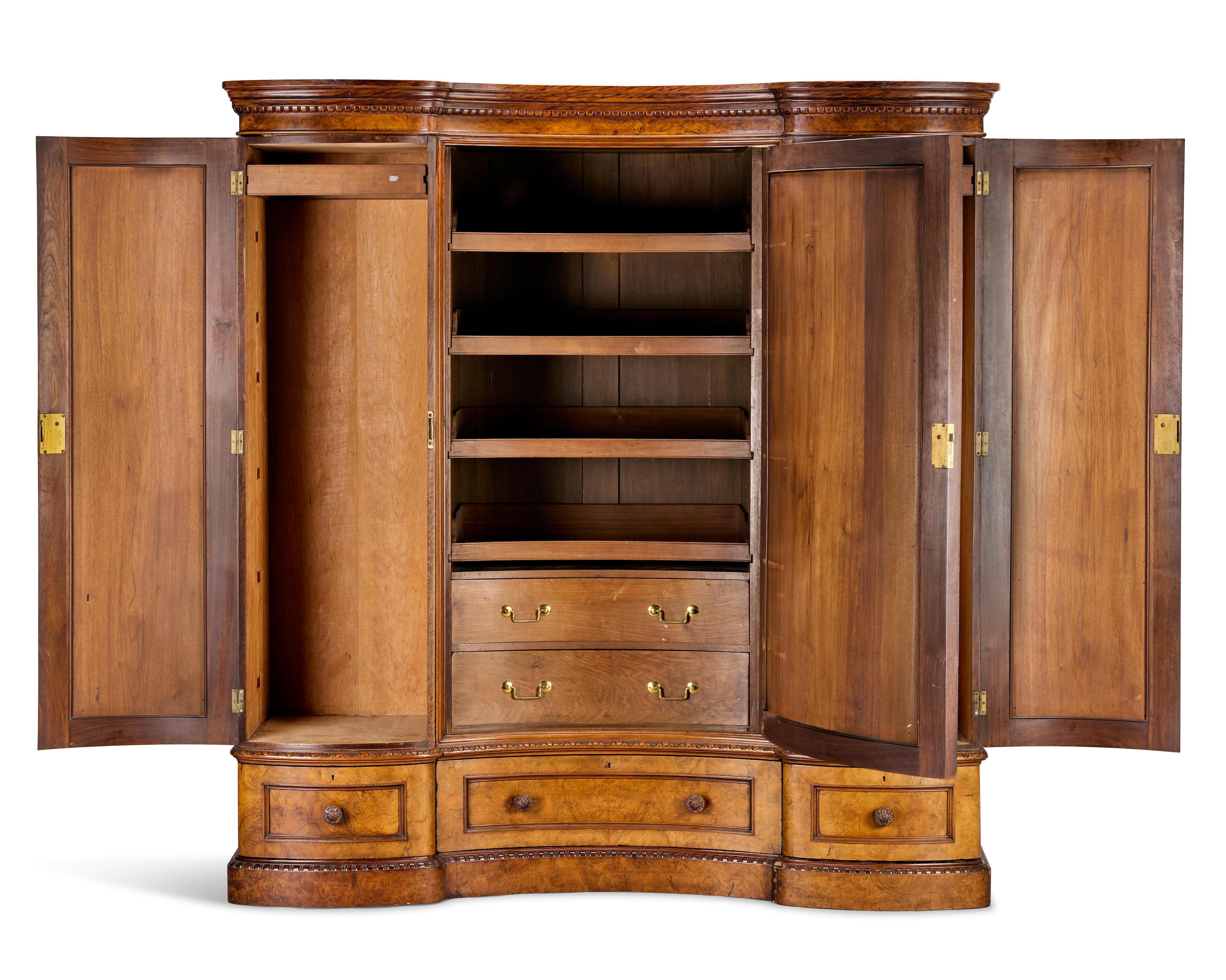 A fine Victorian figured and burr walnut gentleman's compactum or wardrobe

Late 19th century, by Marsh and Jones, Leeds

Of inverted bow front outline, the ogee moulded cornice above a large central panelled door enclosing two drawers and four