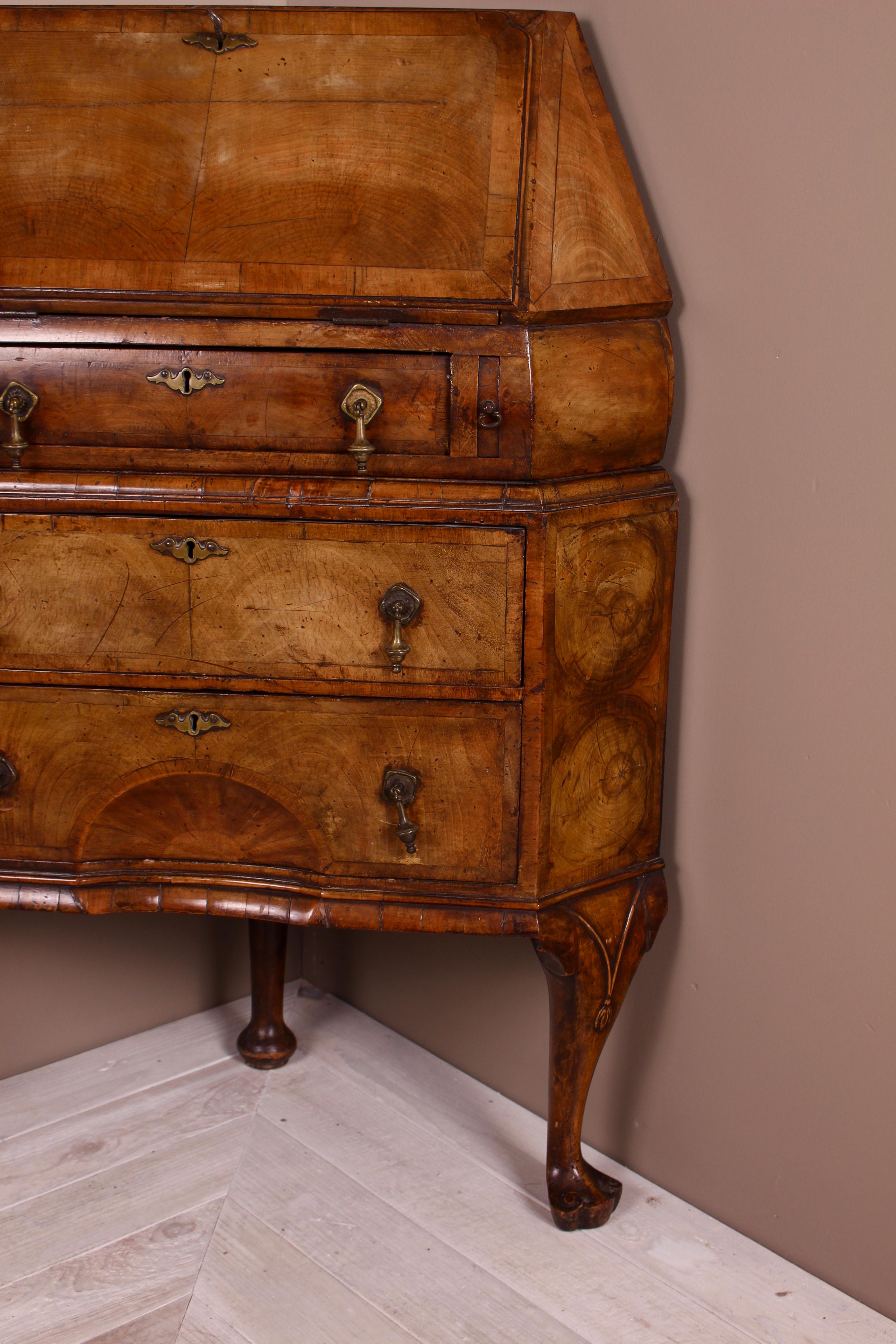A beautifully made and rare walnut corner bureau. In Queen Anne style having a fall front which reveals pigeon holes and two small drawers and a central cupboard. The cupboard being flanked by secret pillar slides complete with original lock and