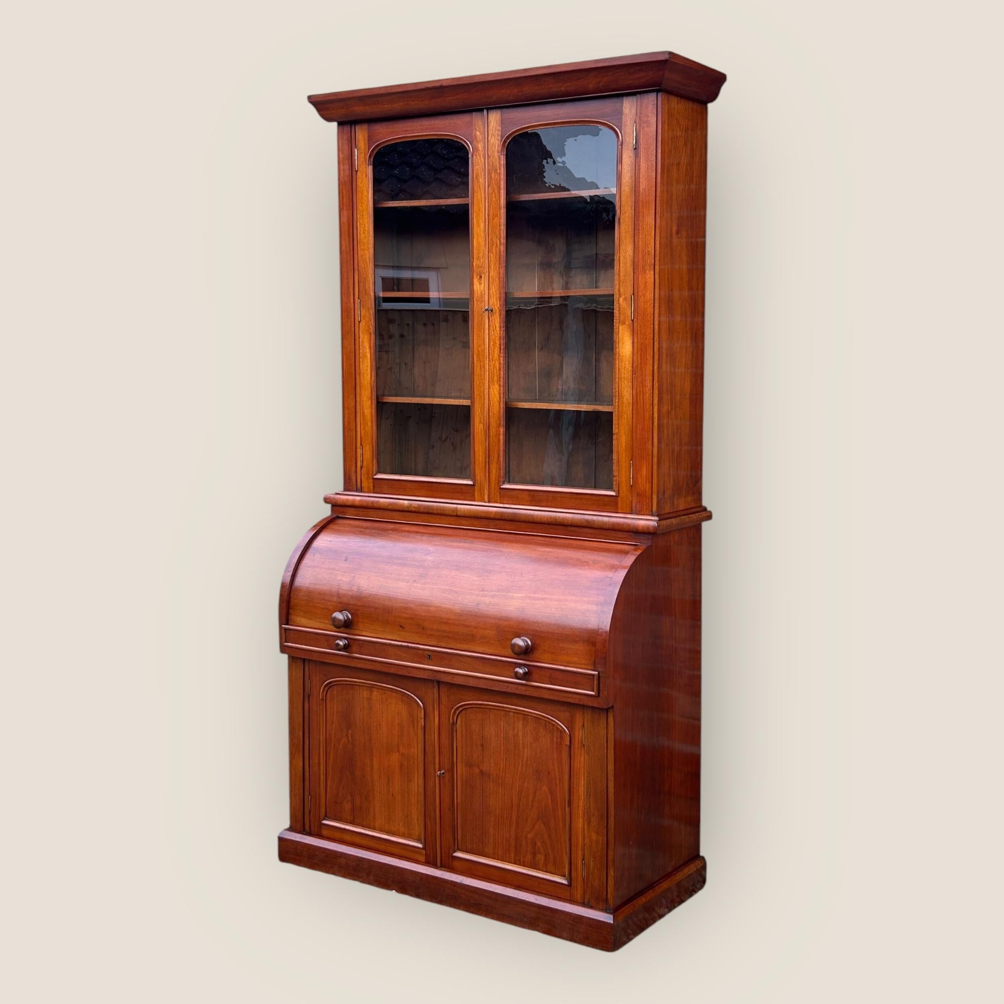 Libreria di presidenza a cilindro in noce di epoca vittoriana. Questo pezzo 3 in 1 è dotato di una libreria, un'area per scrivere e un armadio per riporre gli oggetti: il massimo per l'ufficio di casa! La libreria ha due ante vetrate ad arco che si