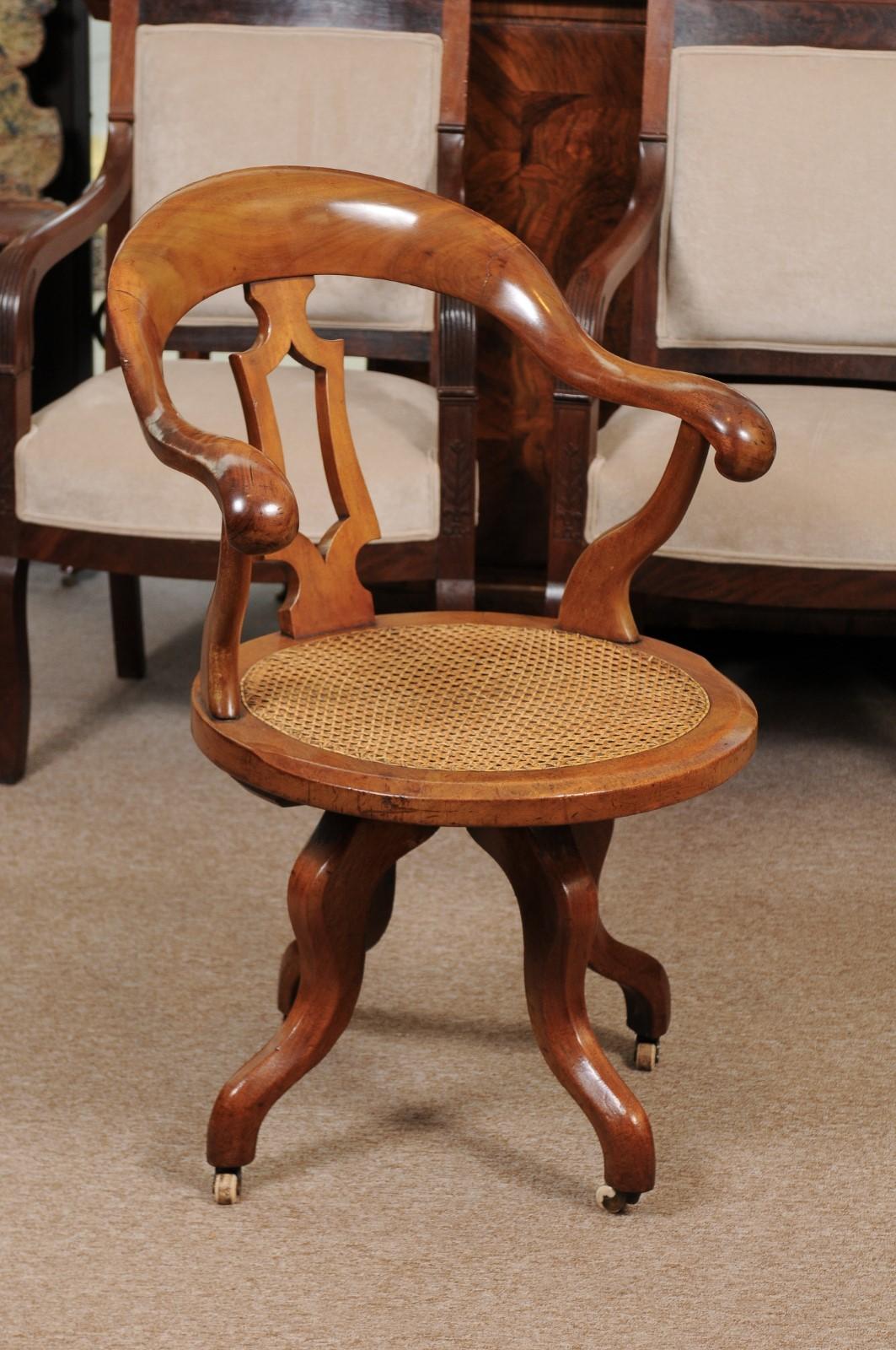 Late 19th century English Victorian swivel desk chair with caned seat.