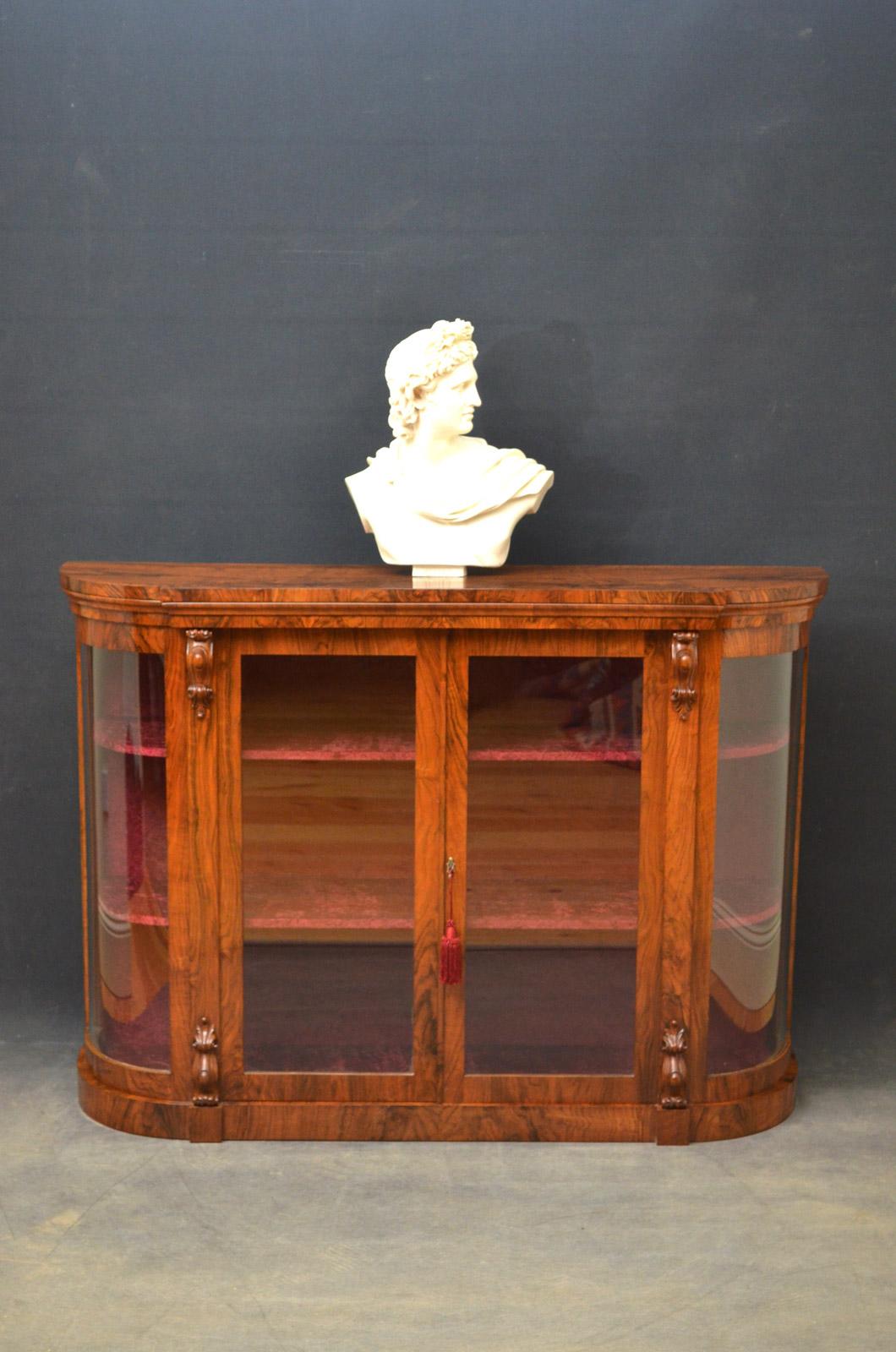 Sn4237 An elegant Victorian walnut display cabinet, having figured top above a pair of glazed doors enclosing crushed velvet interior, flanked by Fine drop carving and bowed glazed ends, all standing on plinth base. This fine cabinet has been