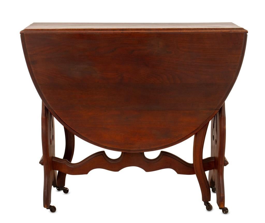Victorian Walnut Drop-Leaf Table, 19th century, with two lyre form legs and two gate legs on casters. 29