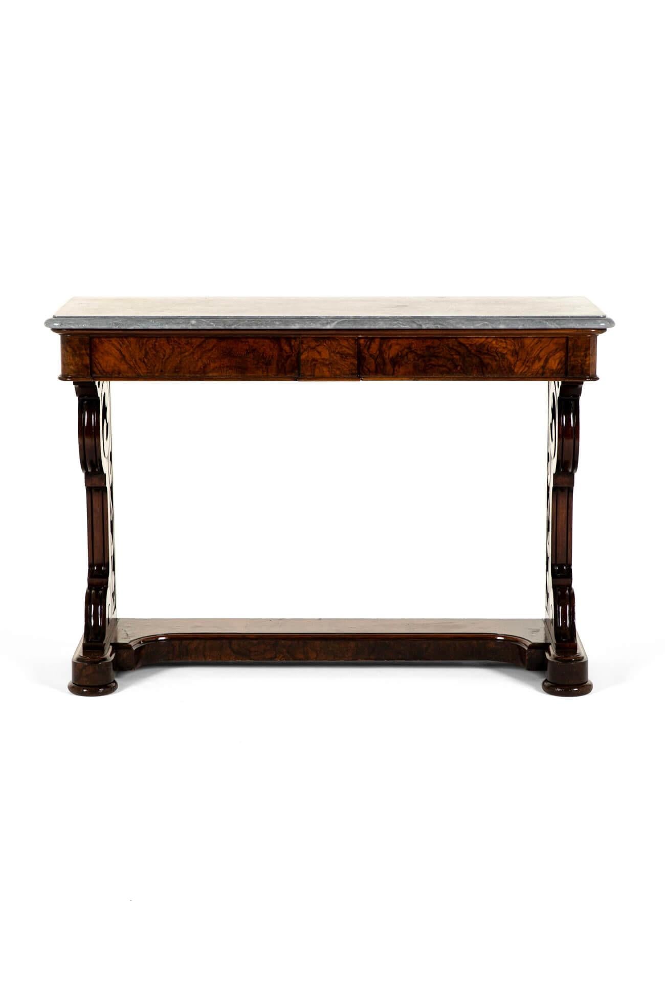 A sublime Victorian entrance hall side table in walnut with a beautiful grey marble figured top.

The generous molded top sits above two long frieze drawers with beautifully shaped pierced end supports.

The table has an incurve base united by a