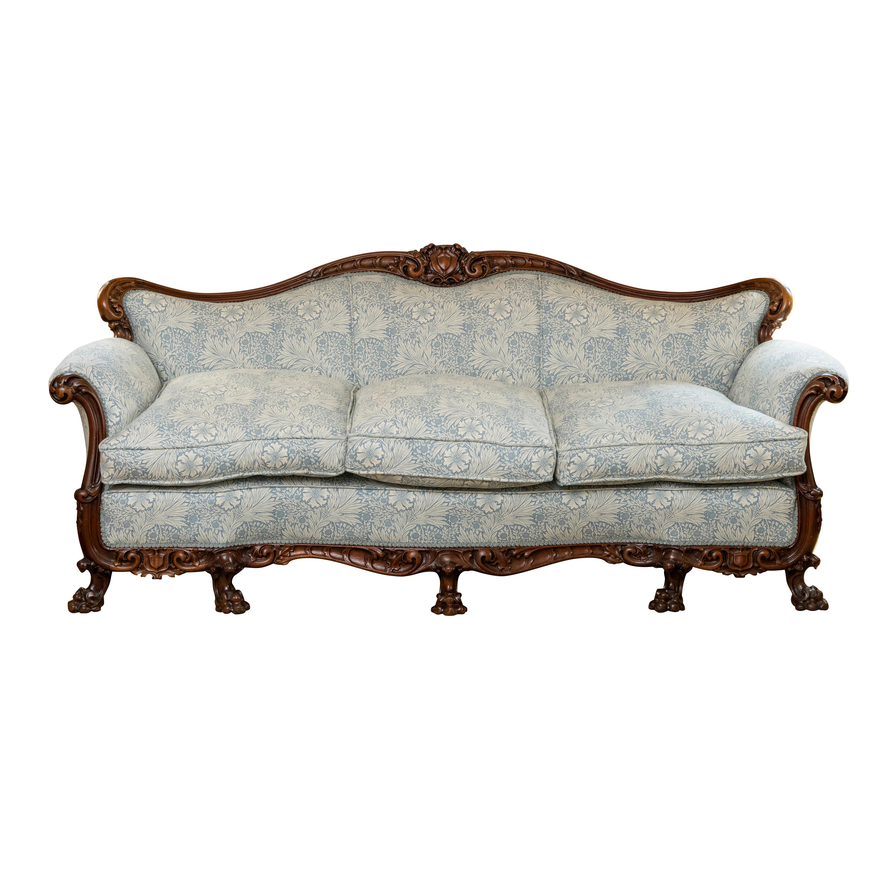 A Victorian Walnut framed Settee of serpentine form.
The shaped top frame carved profusely with scrolling holly leaves, centred by a cartouche.
Shaped carved side arms. The base apron again carved profusely with holly leaves, armorial cartouches