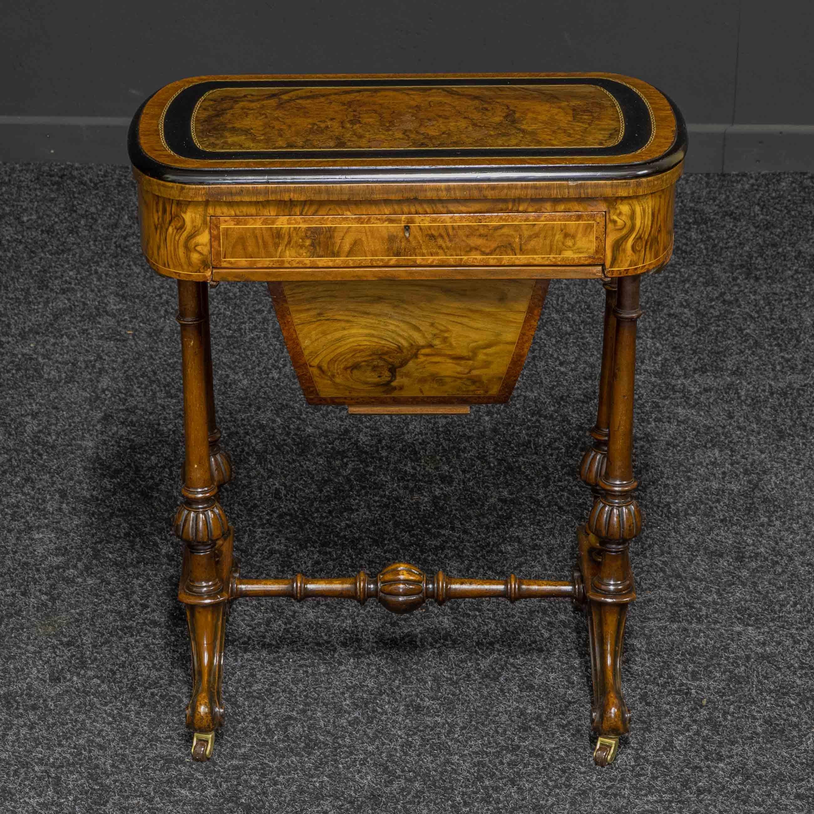 A superb Mid Victorian burr walnut veneer games/sewing table of much above average quality. Sat on it's original brass and pot castors rising on swept cabriole legs with a turned and fluted central stretcher. Matched with double turned end supports